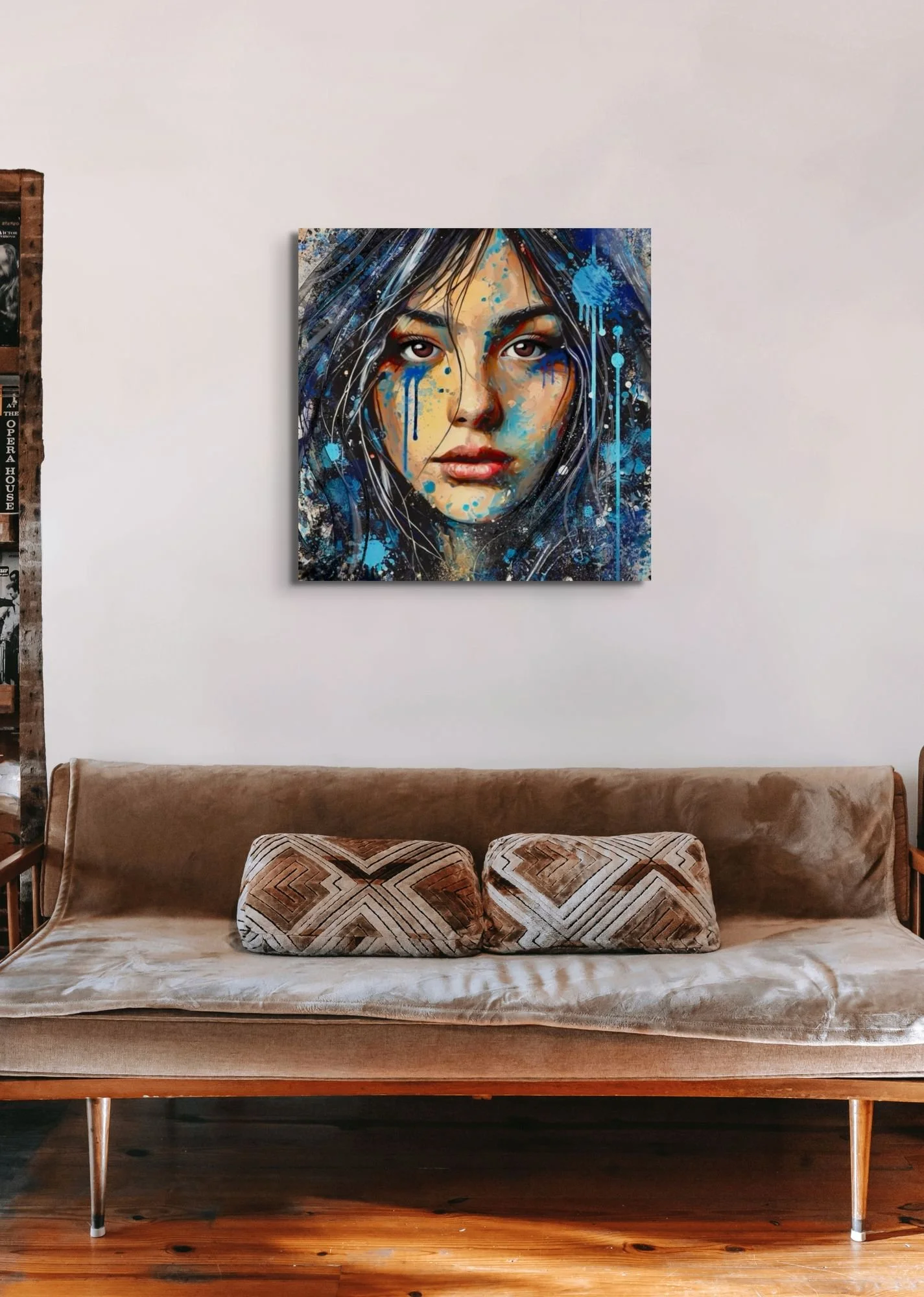 Blue feminine portrait wall art displayed above a bed in a modern bedroom with expressive contemporary decor and moody abstract textures.