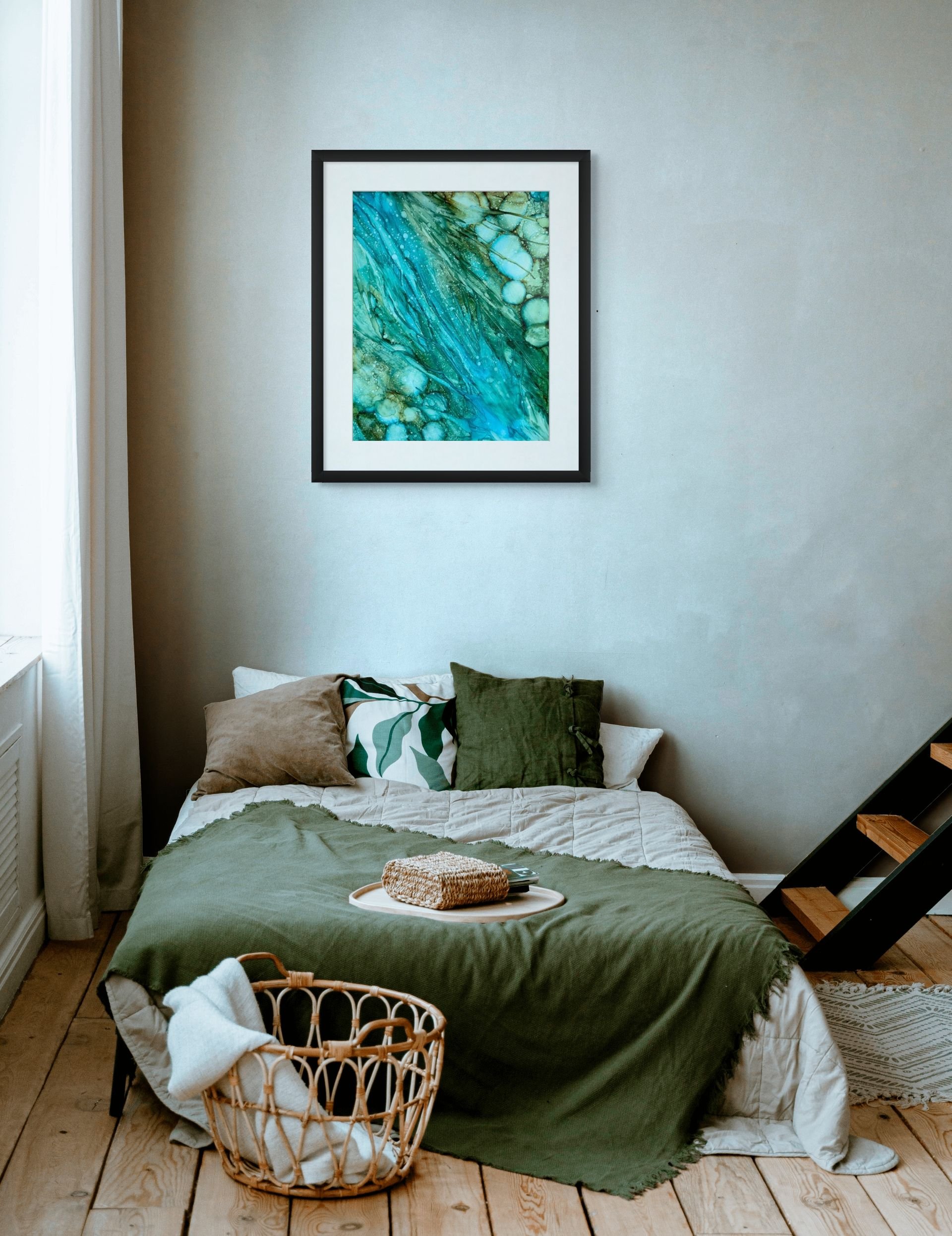 Turquoise and emerald abstract wall art framed above a bed in a serene coastal bedroom with modern beach house decor.