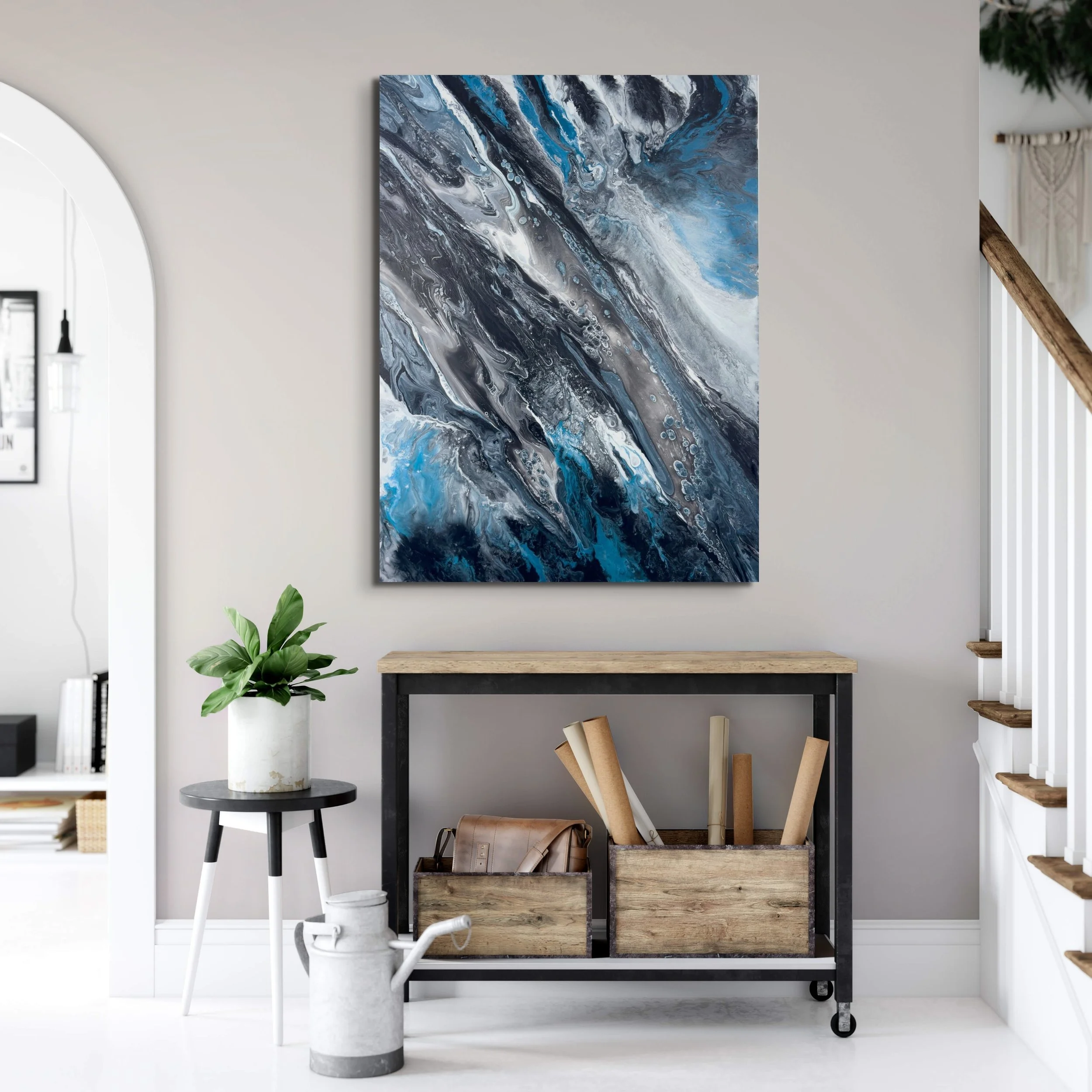 Contemporary abstract canvas wall art with black, white, silver, and blue marbled movement displayed in a minimalist modern living room interior with luxury home decor styling.