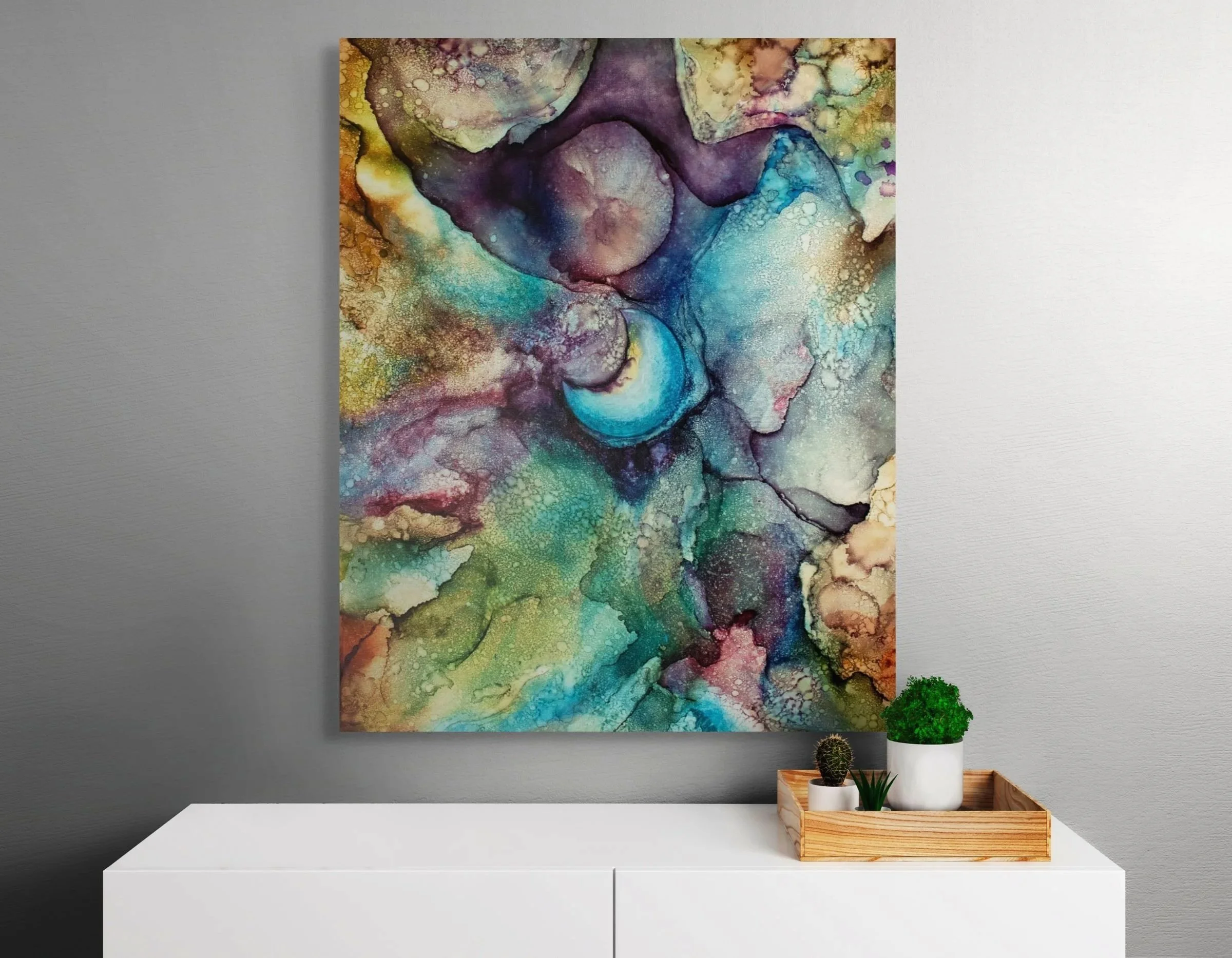 Abstract alcohol ink wall art displayed above a modern console table with celestial teal, gold, and purple textures for stylish home decor.