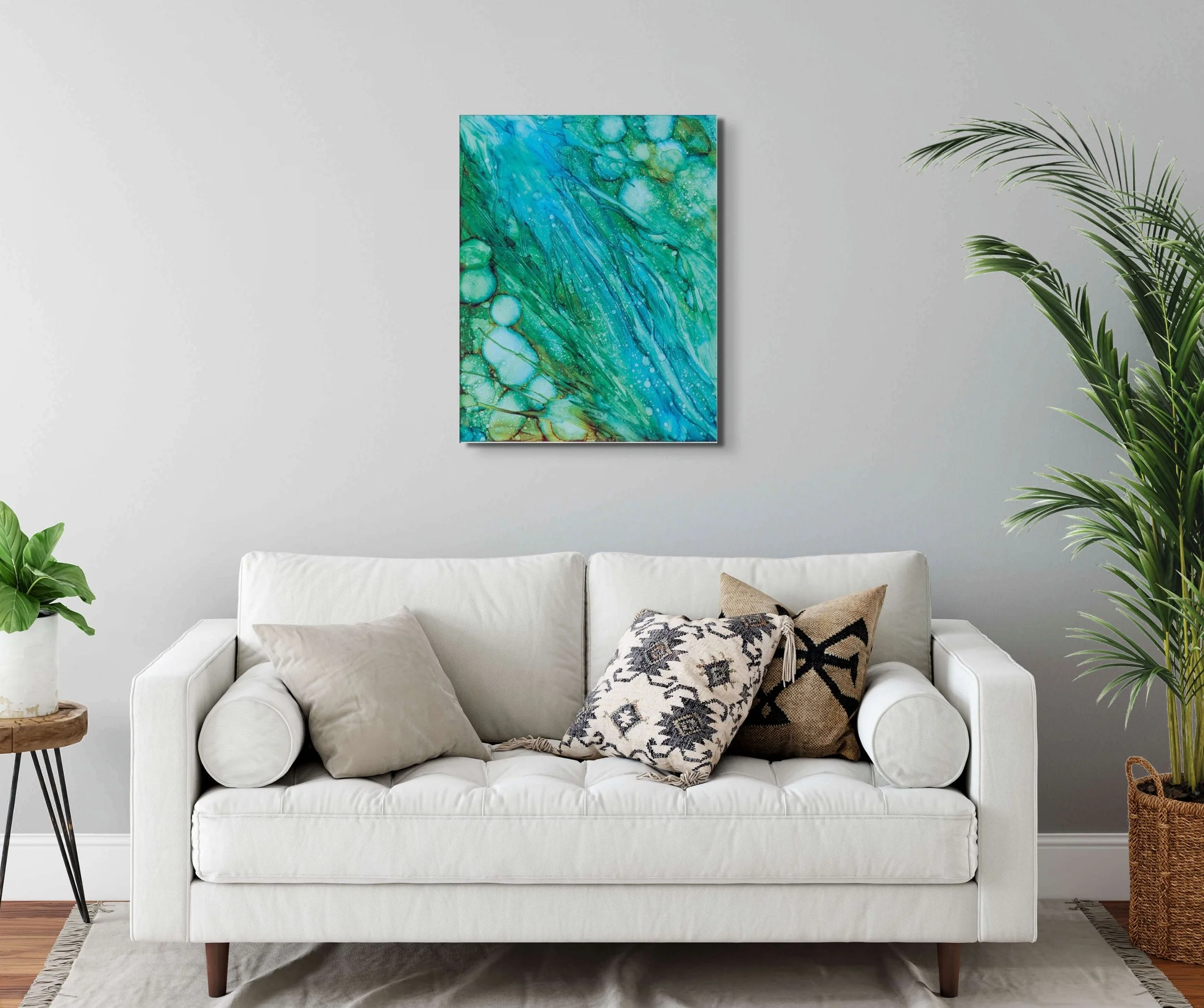 Green coastal abstract wall art displayed above a white sofa in a modern living room with calming ocean-inspired home decor.