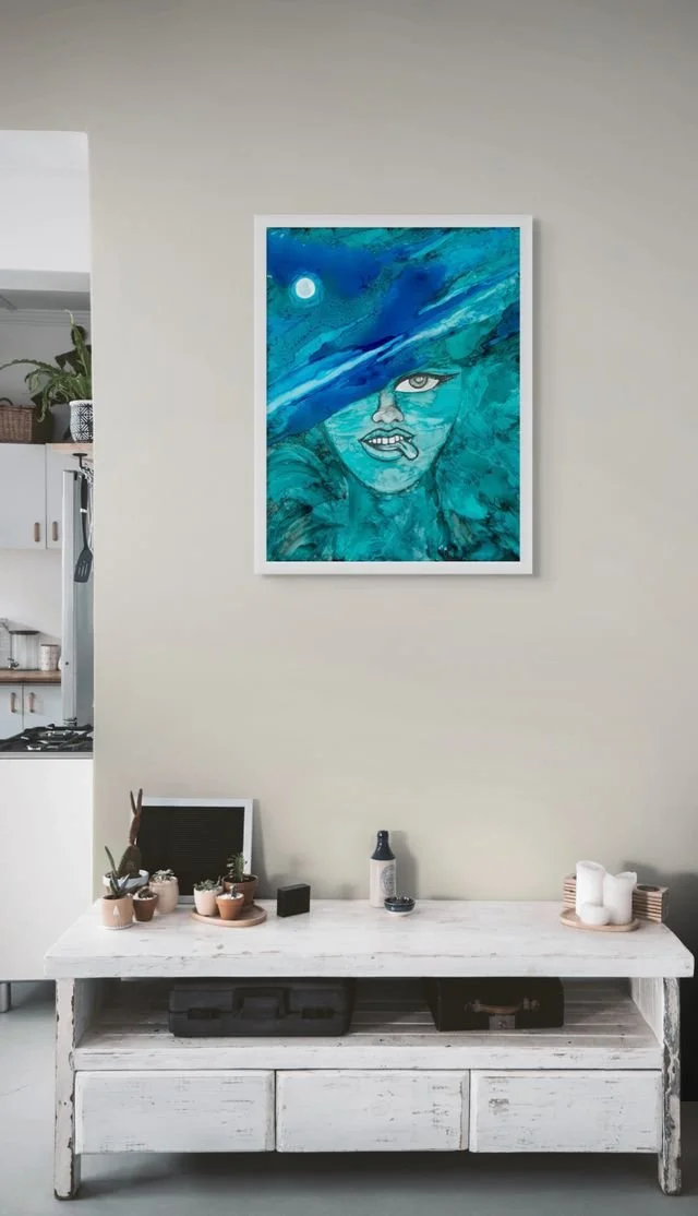 Blue coastal woman portrait wall art with turquoise ocean textures displayed in a modern beach-inspired interior space.