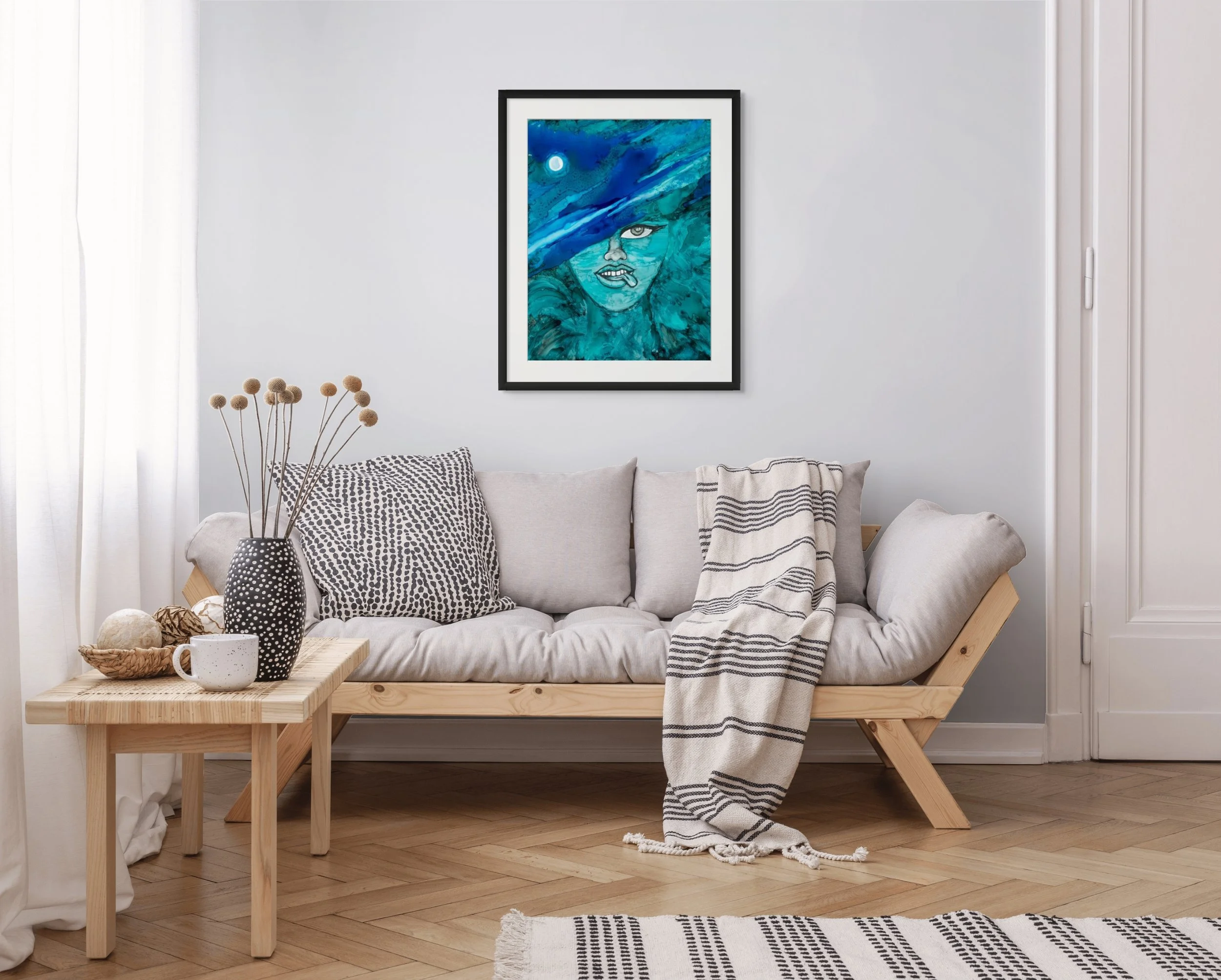 Blue coastal woman portrait wall art displayed in a modern living room with ocean-inspired textures and calming beach house decor styling.