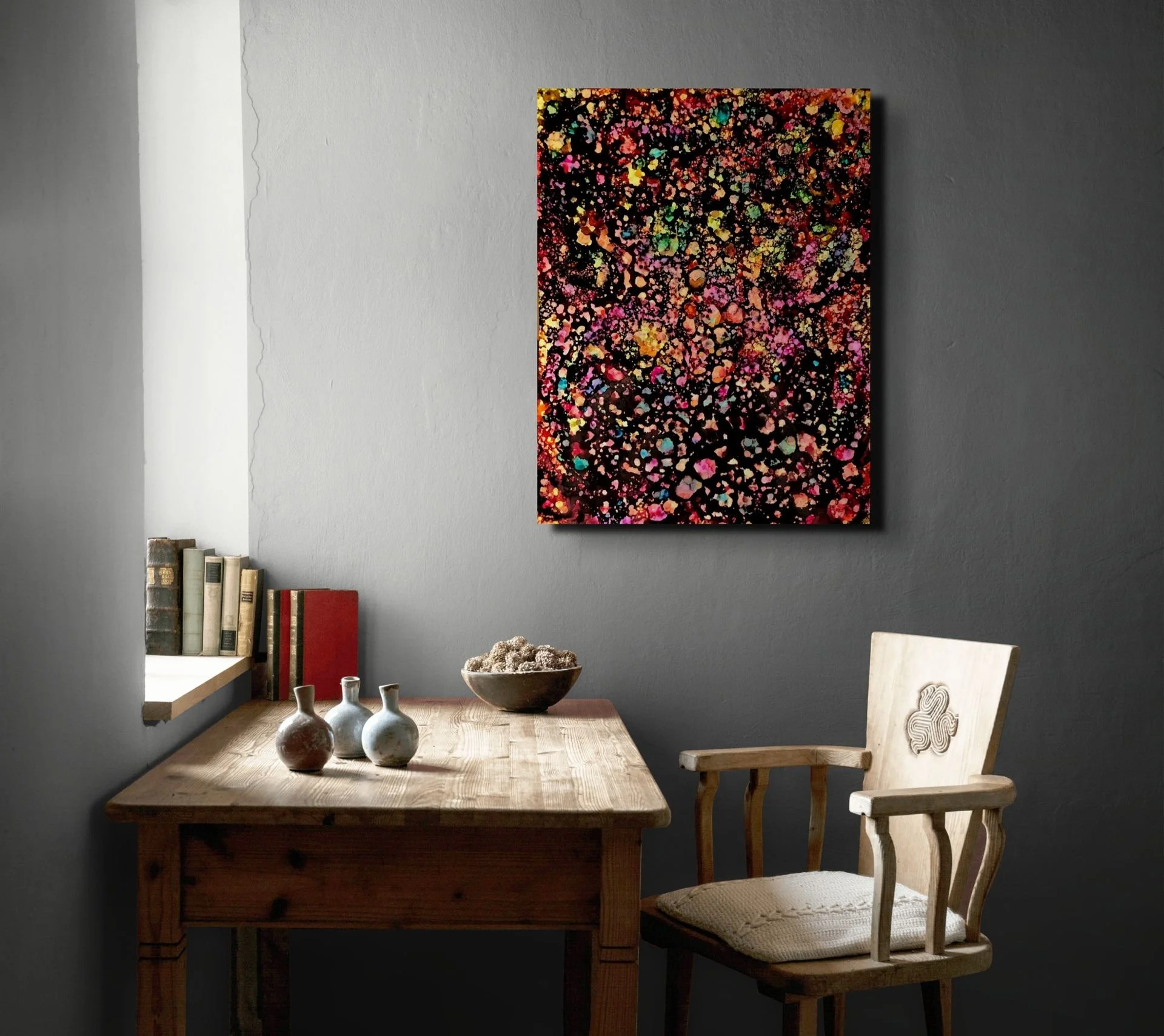 Abstract vibrant painting showcased in a home office setting with warm lighting.