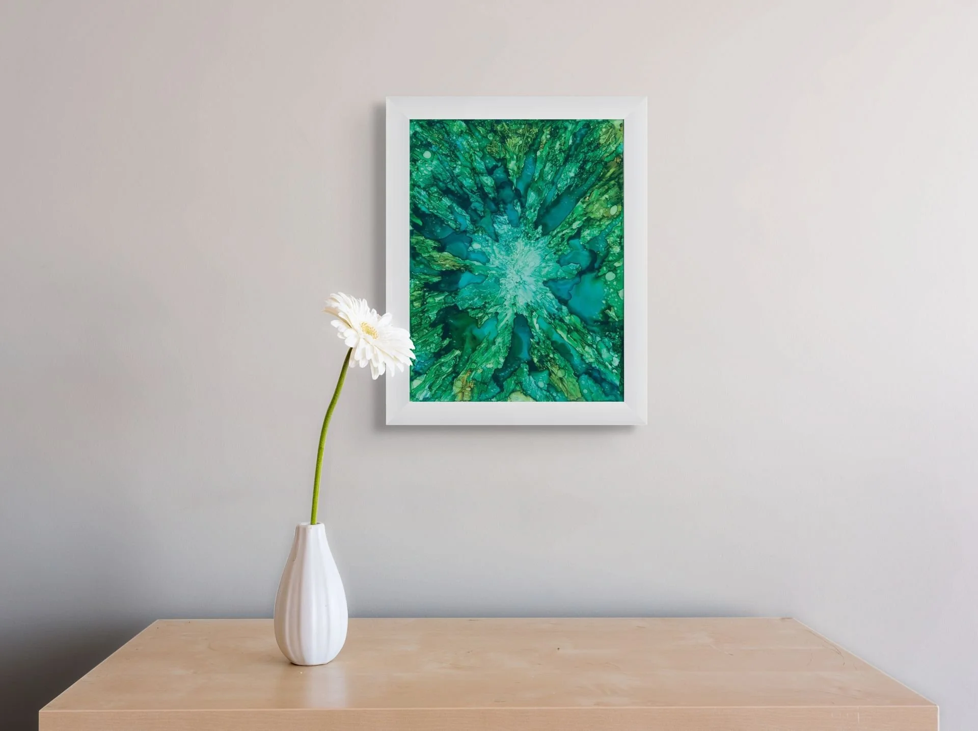 The Pull Inward abstract alcohol ink art print in white frame styled on wall with coastal home decor by Nadeane Friend