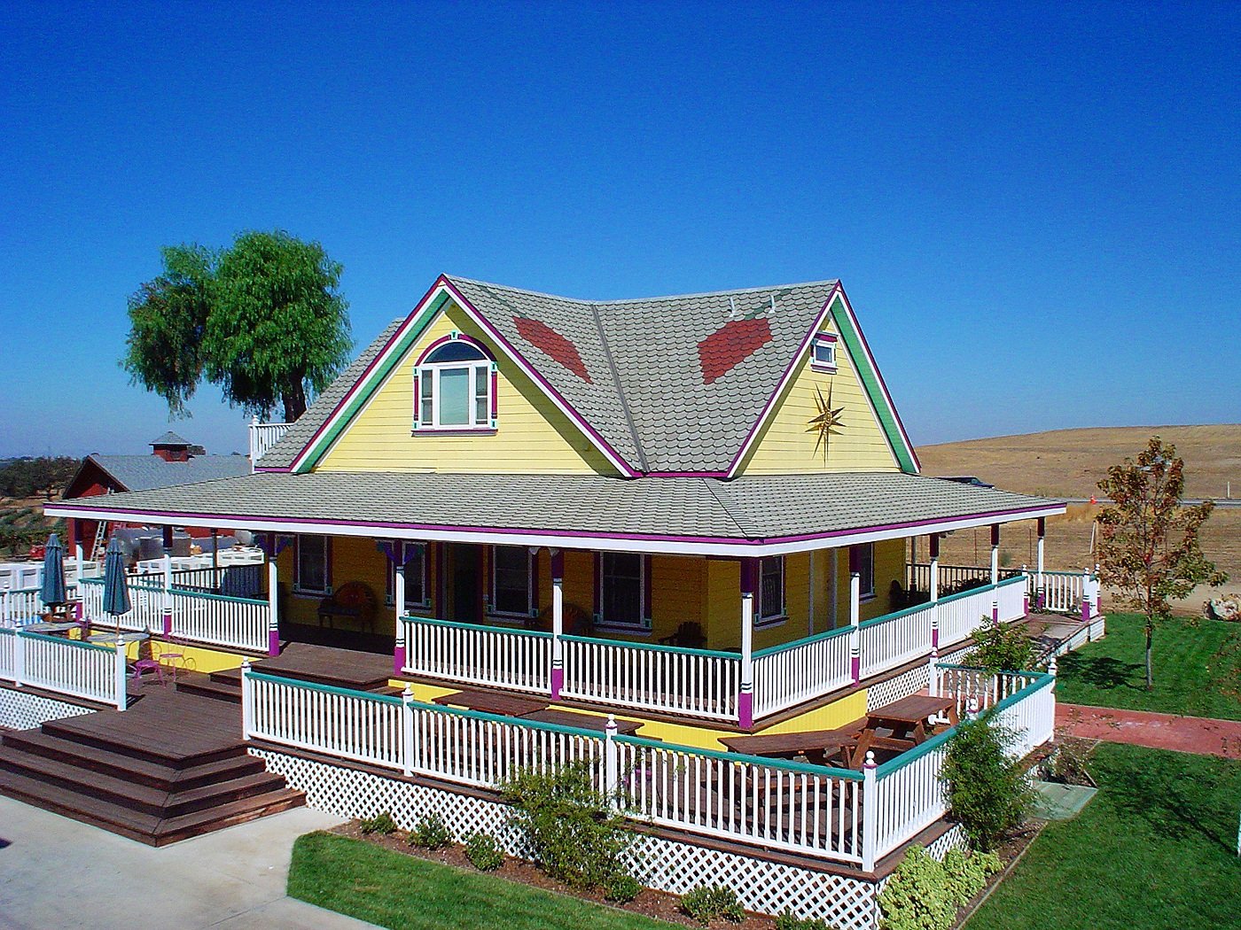 Yellow Guest House with grapes on roof