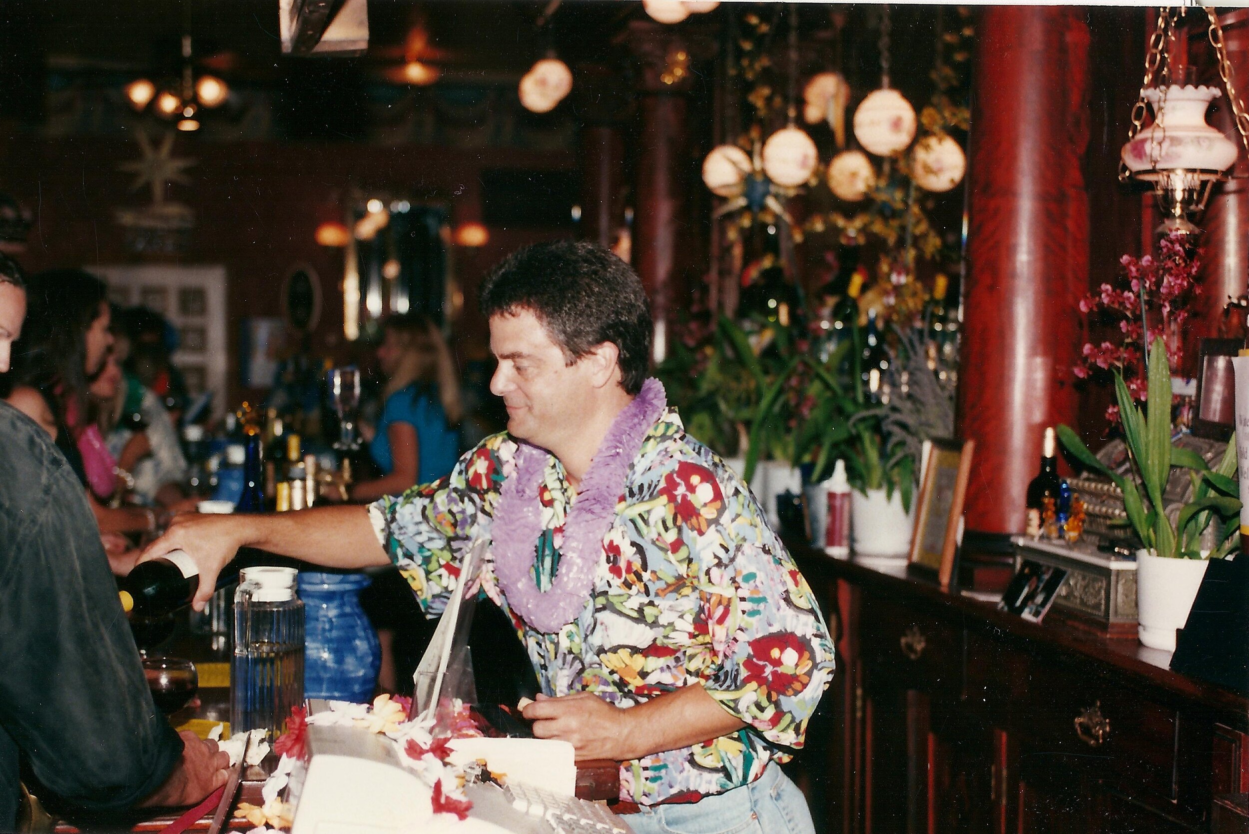 lance pouring wine at the bar in Hawaiian shirt