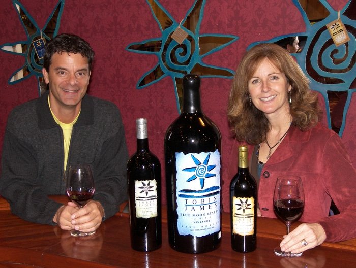 Lance and Claire at bar with three wine bottles