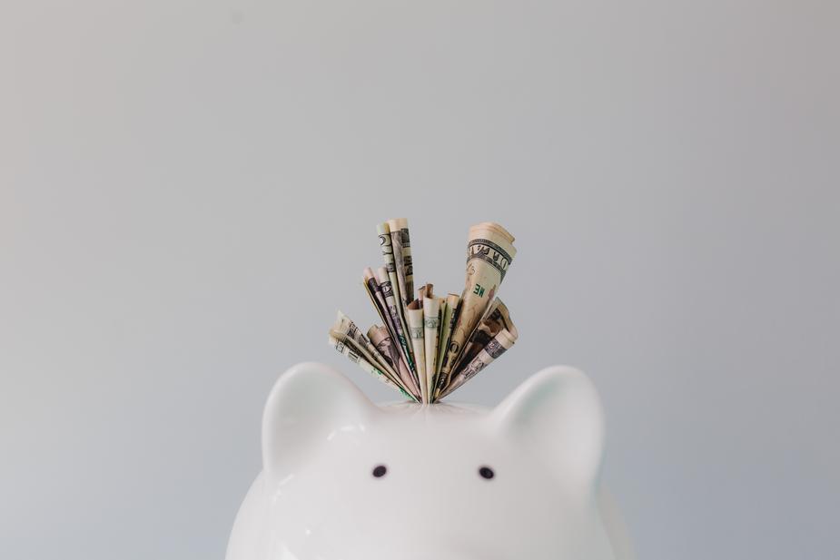 dollar-bills-stuffed-in-piggy-bank_925x.jpg