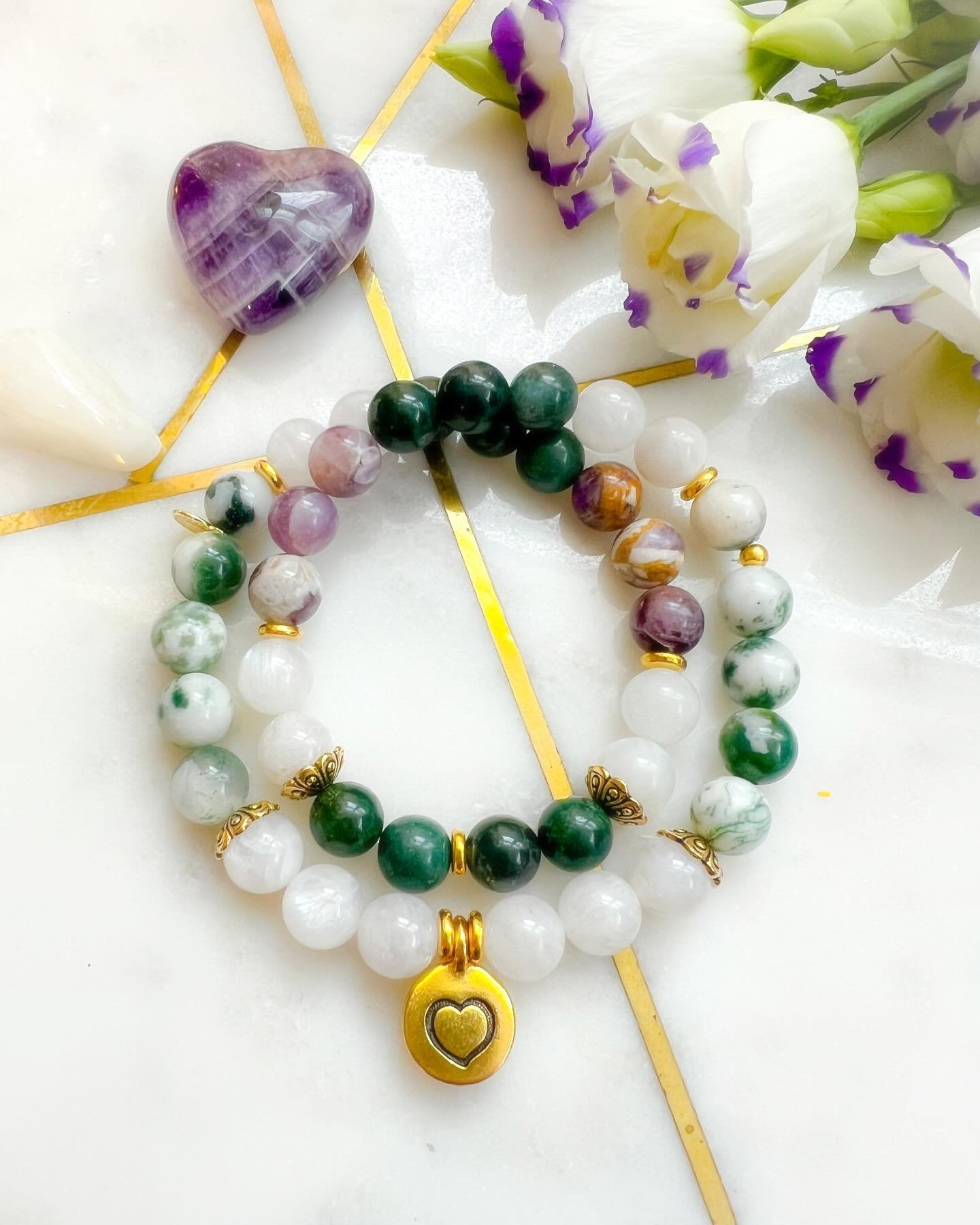 A commission, titled Bravery. The intentional bracelet is made with nurturing Moonstone, protective Tree Jasper, intuitive Chevron Amethyst, and heart healing Green Moss Agate. 🤍💚💜