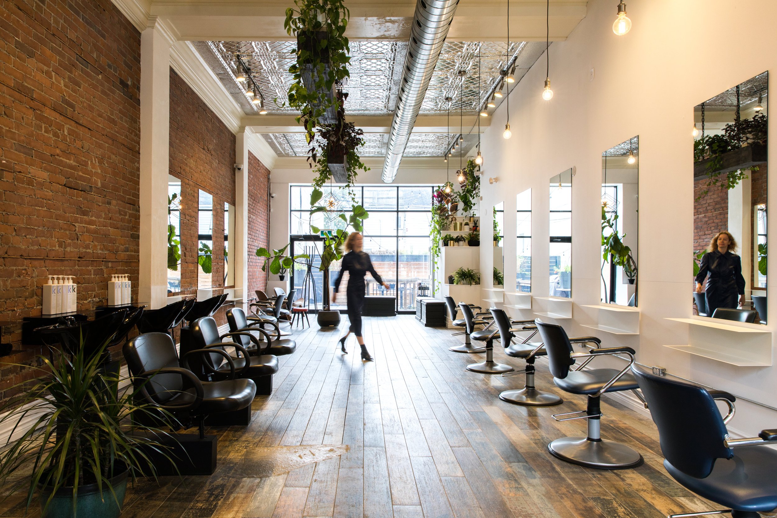Top hair salon based in Toronto with floor to ceiling windows and exposed brick walls