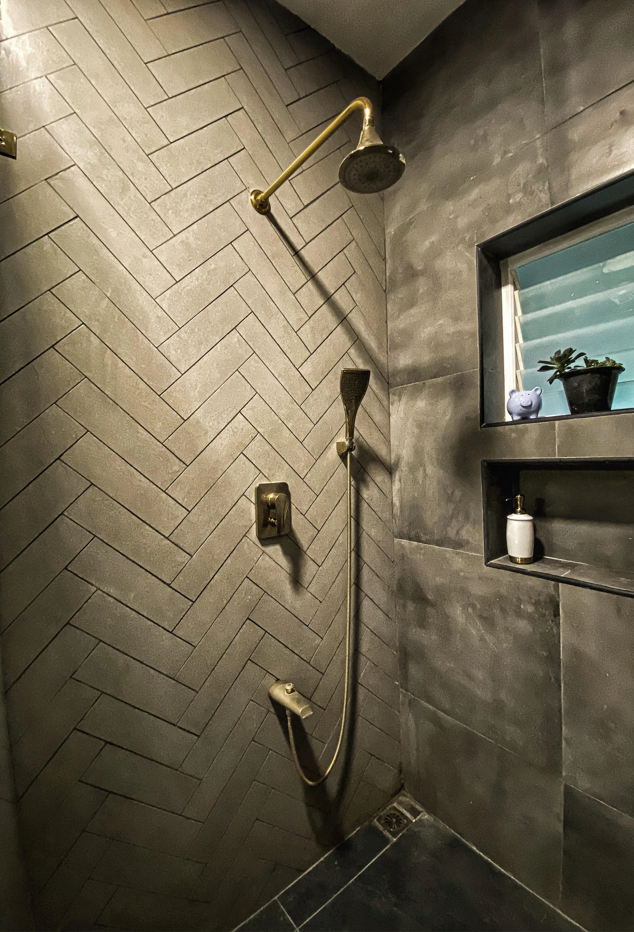 HOLY HERRINGBONE! We custom chose the tile, color and size we wanted for the herringbone patterned tile feature wall. By using a precise water jet cutting technique we got the desired effect we wanted. A darker grey epoxy grout brings out the pattern and tile formation of this gorgeous shower wall.