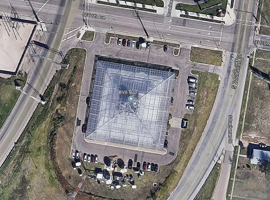 A closer-in satellite view, looking down on the TV station’s pyramidal roof: To get a sense of the building’s scale, one can compare it with the cars which are parked to the North, East, and South. At the bottom of the picture (at the South, just below the line of parked cars) is an array of the numerous types of antennas used by the station. Image courtesy of Google: Imagery ©2019 Google, Imagery ©2019 Maxar Technologies.