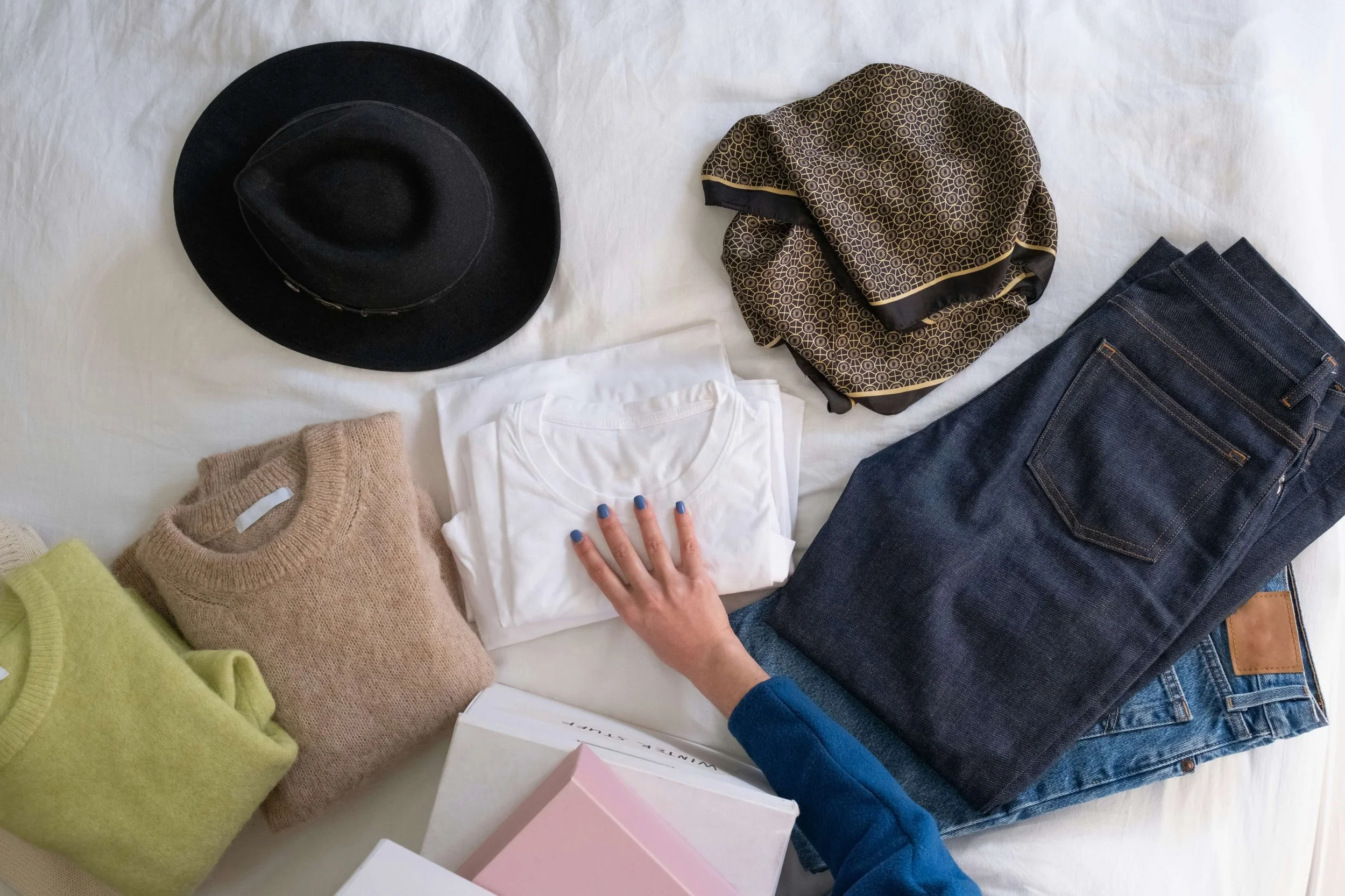Woman folding up clothes with a hat