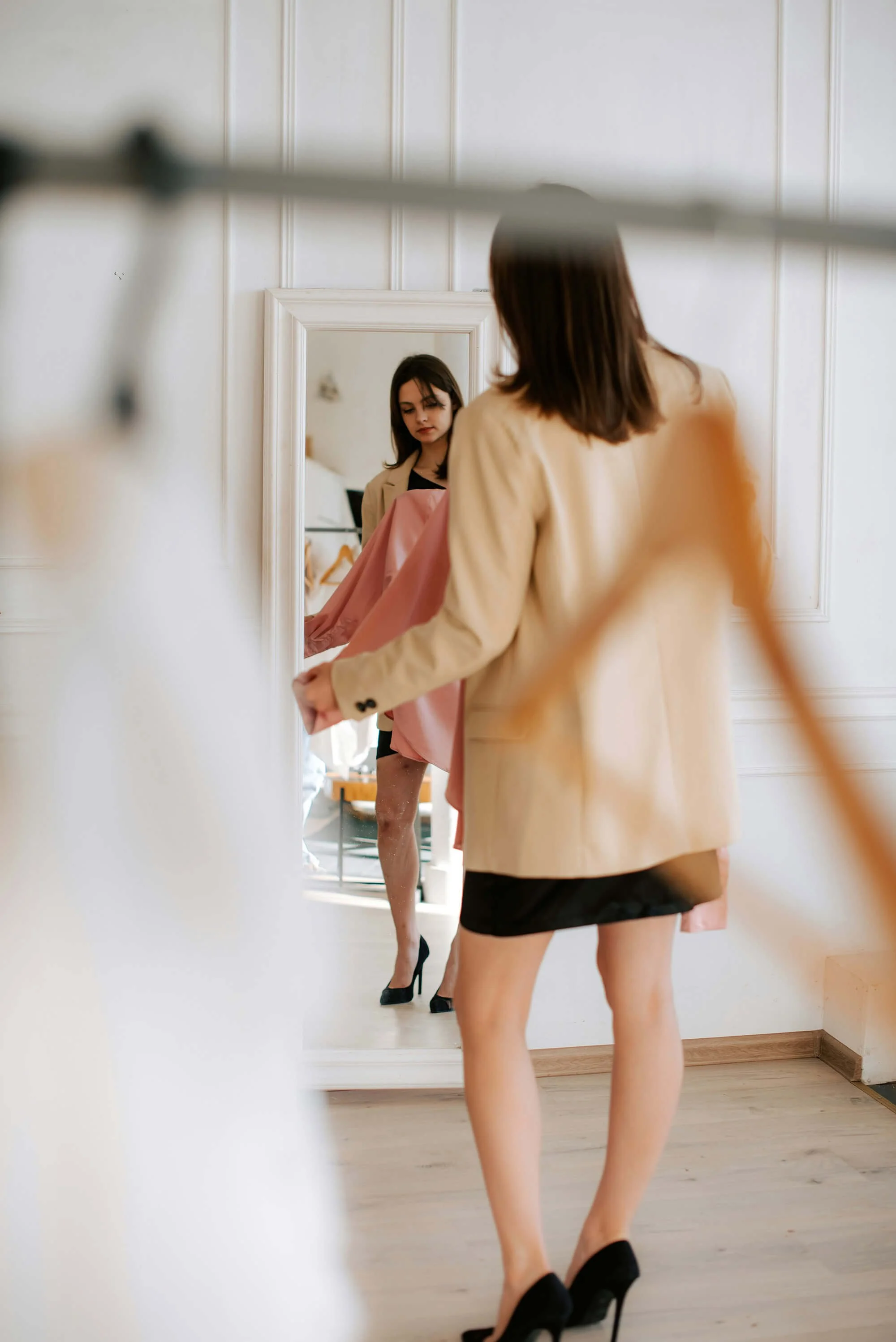 Woman looking at outfits in front of the mirror