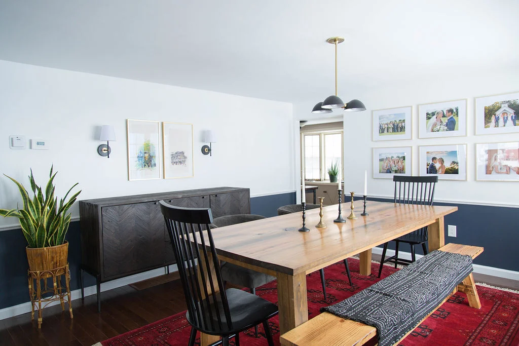 Dining room with handcrafted wood table, chairs and bench seating, gallery wall, white and navy paint colors