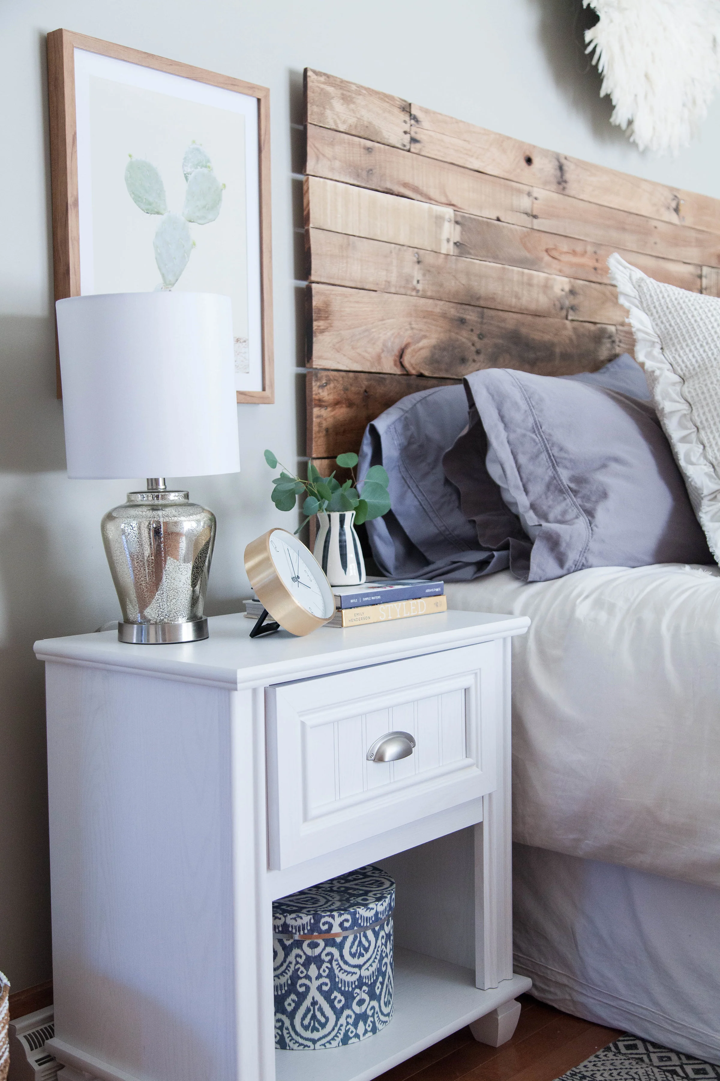 Guest house bedroom nightstand with mixed metals and handmade wood headboard in Hamilton, NY