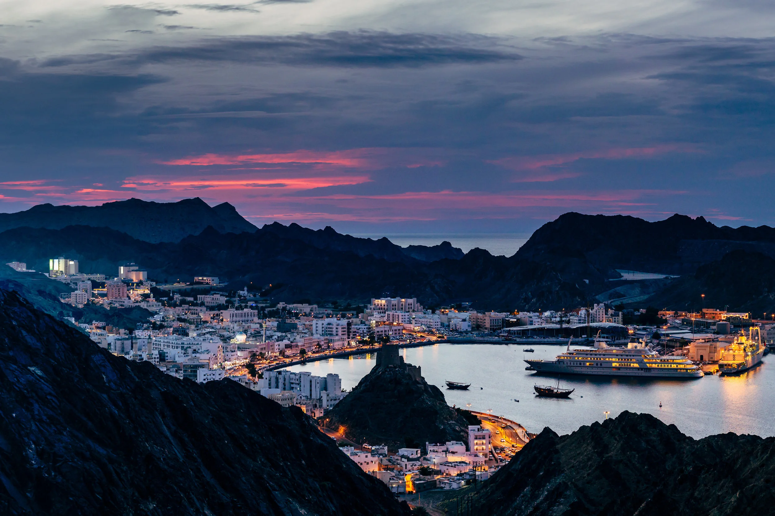 The sun sets behind the old city of Muttrah, one of the oldest ports in the Middle East.