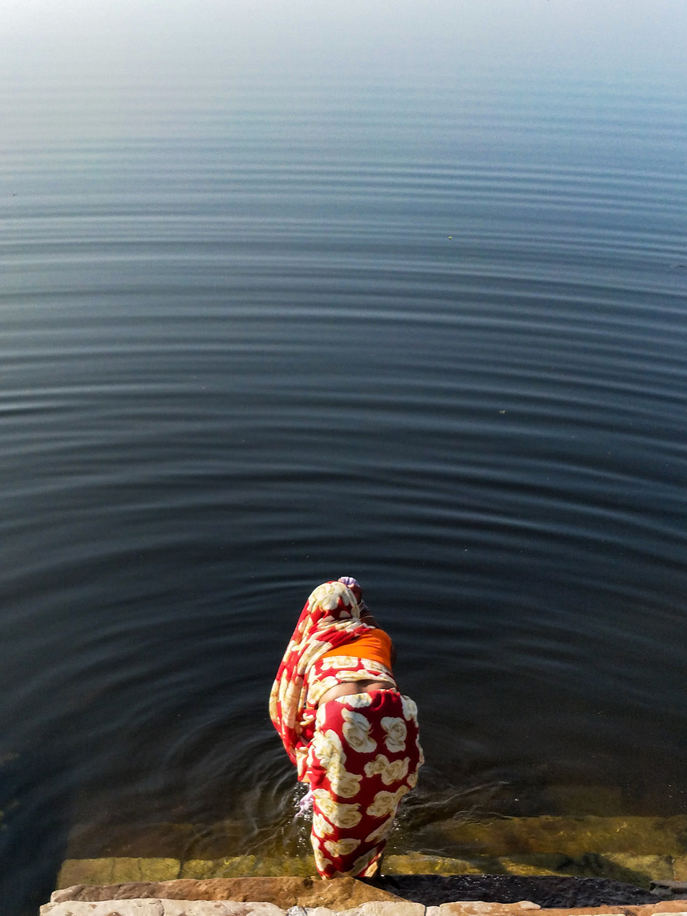 Walking around the Brahma temple, I met a woman sitting beside a lake at sunset with tears rolling down her face.