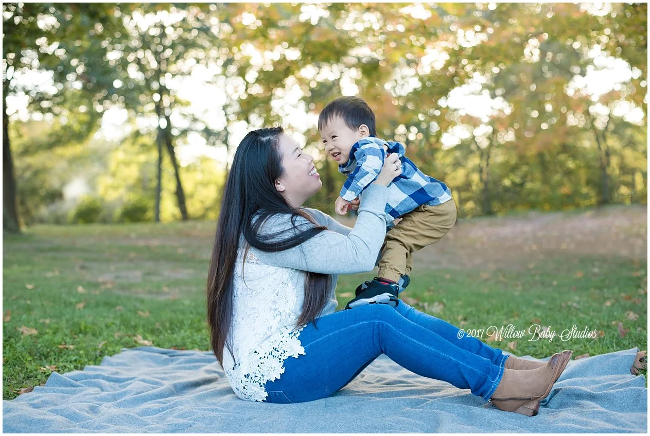 momma holding her little boy on her lap outside