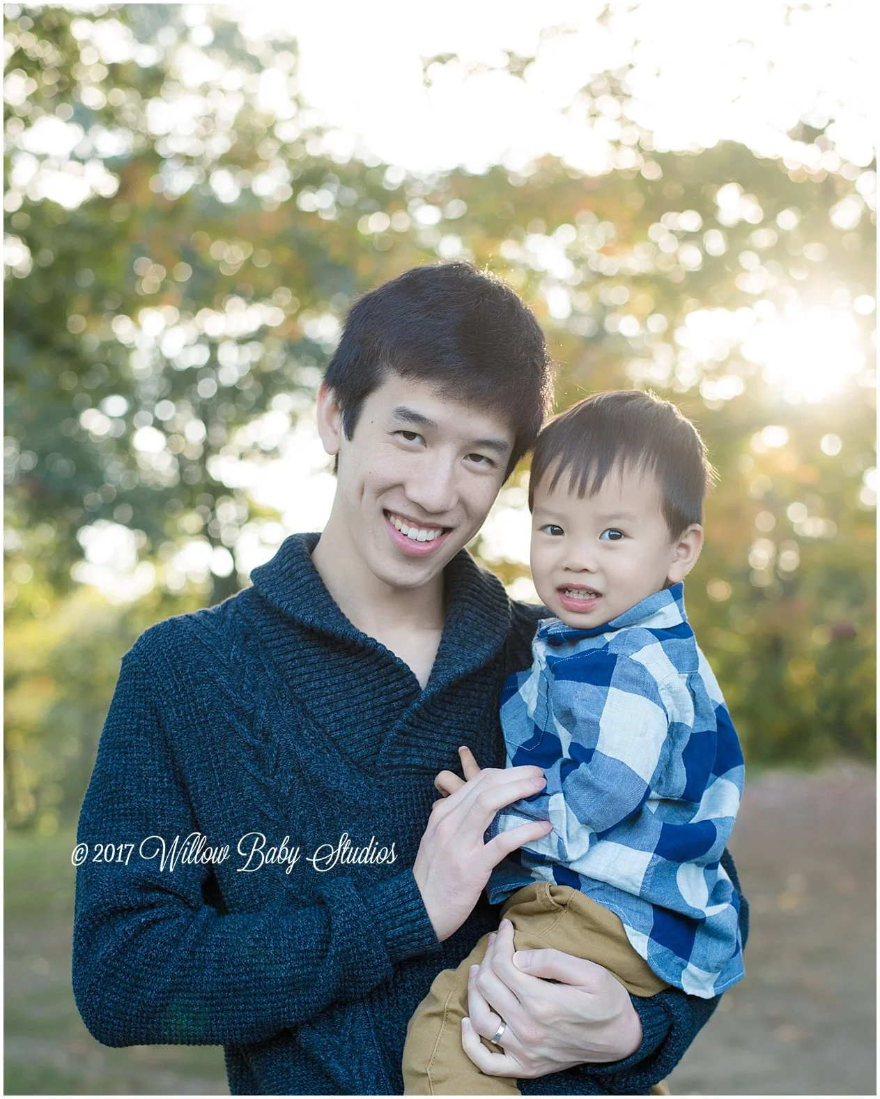 dad holding his young son at sundown