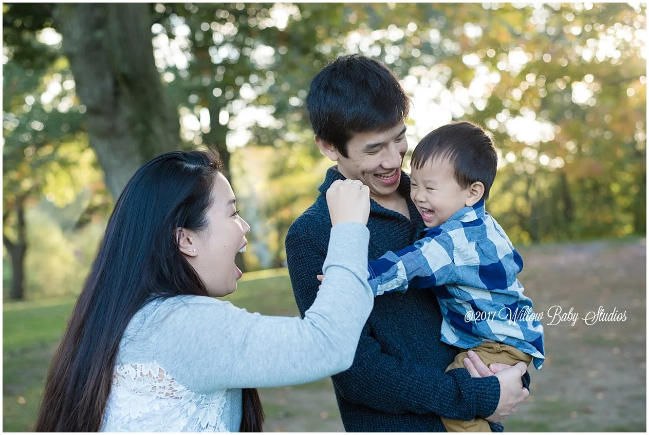 mom and dad teasing their happy toddler with snacks