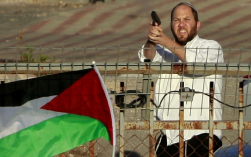 An Israeli Jewish settler shoots in the air as Palestinians protest against the forced relocation of Israel’s Palestinian Bedouin minority from their villages in the Negev Desert.