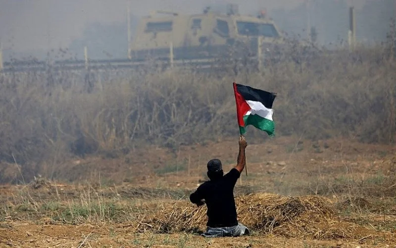 Palestinian demonstrator Ibrahim Abu Thurayeh, who lost his legs in a 2008 Israeli airstrike, waves a Palestinian flag during clashes with Israeli soldiers near the border fence east of Gaza City, May 19, 2017. (AFP Photo/Mohammed Abed/File) Abu Thurayeh was killed by an Israeli soldier December 15, 2017.