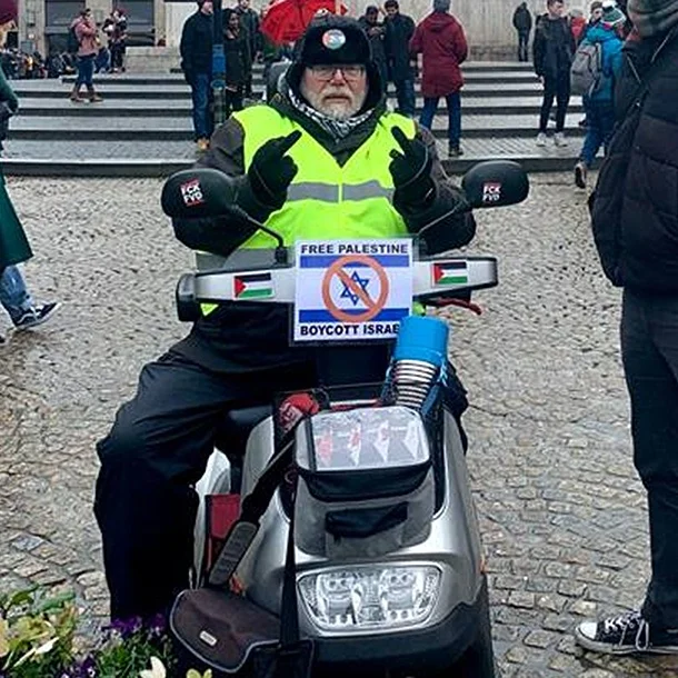 Robert-Willem van Norren promoting a boycott of Israel atop an Israel-made mobility scooter in January 2019. (Michael Jacobs)