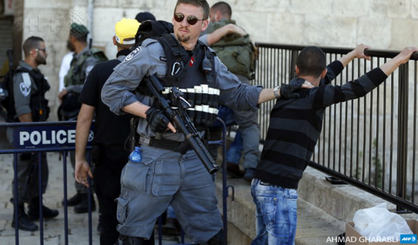 Israeli forces stop and search a Palestinian boy at the entrance of Damascus Gate, outside Jerusalem's Old City, on February 19, 2016 (AFP)