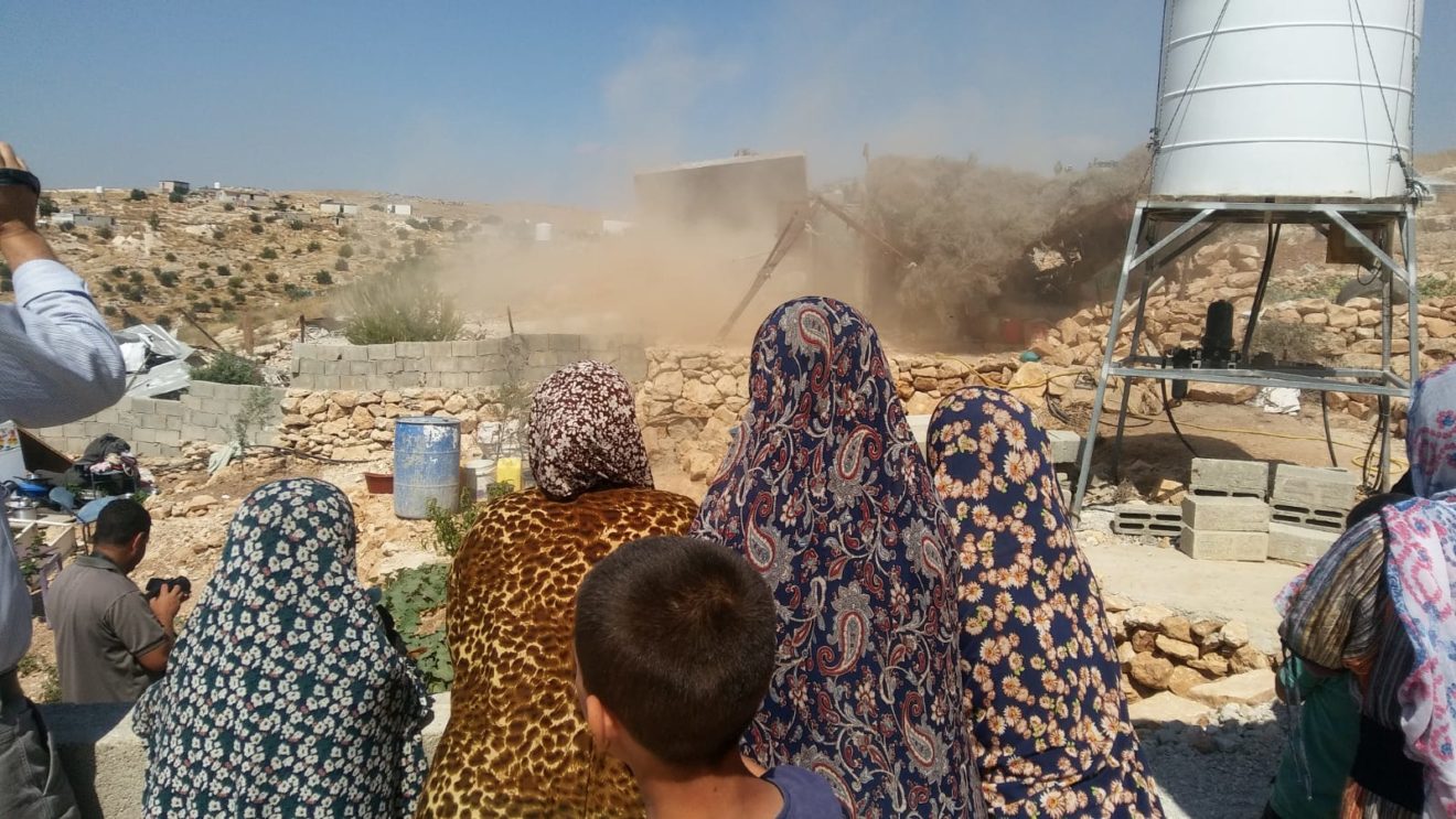 The al Dababsh family watches as their home is razed to the ground in the village of Khalet al Dabeh