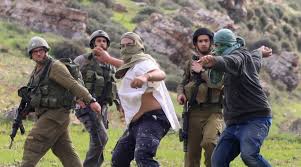 As Israeli soldiers watch, Jewish settlers from the settlement of Yitzhar throw rocks at Palestinian farmers near the city of Nablus in the occupied West Bank. (PHOTO: Emad Drimly Xinhua/Zumapress)