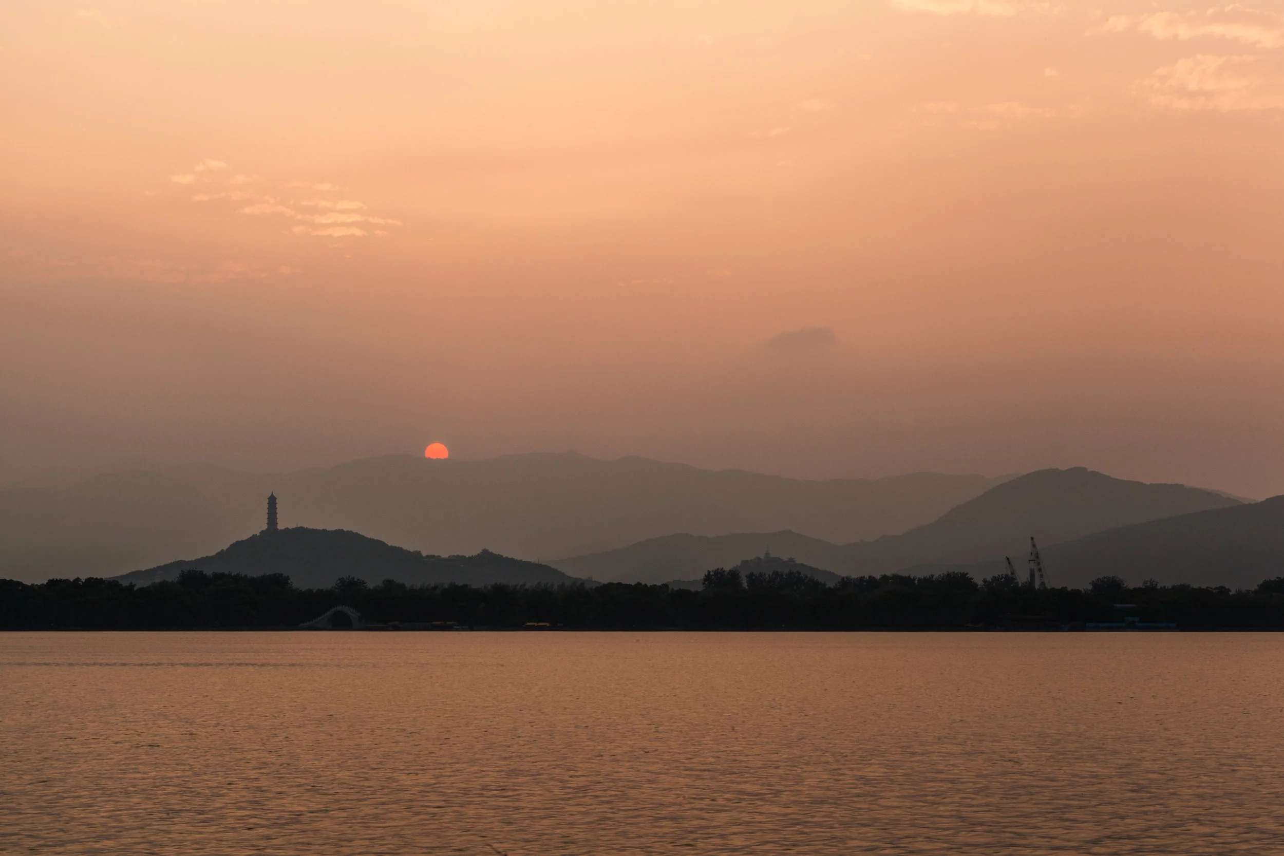 Sun setting behind the mountains at the Summer Palace in China.