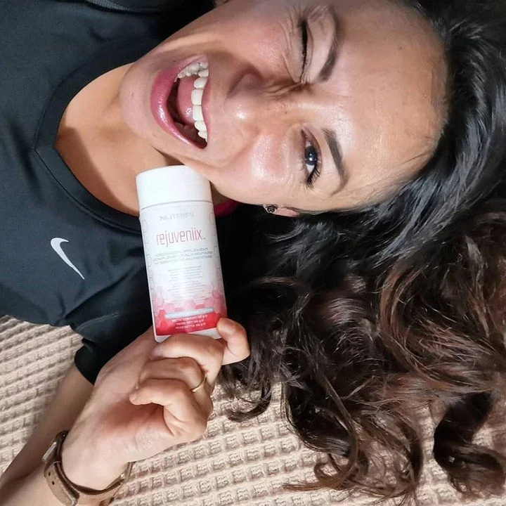 Woman Holding a Bottle of Nutrifii Rejuveniix - Energy Boost Supplements - Close to Her Face