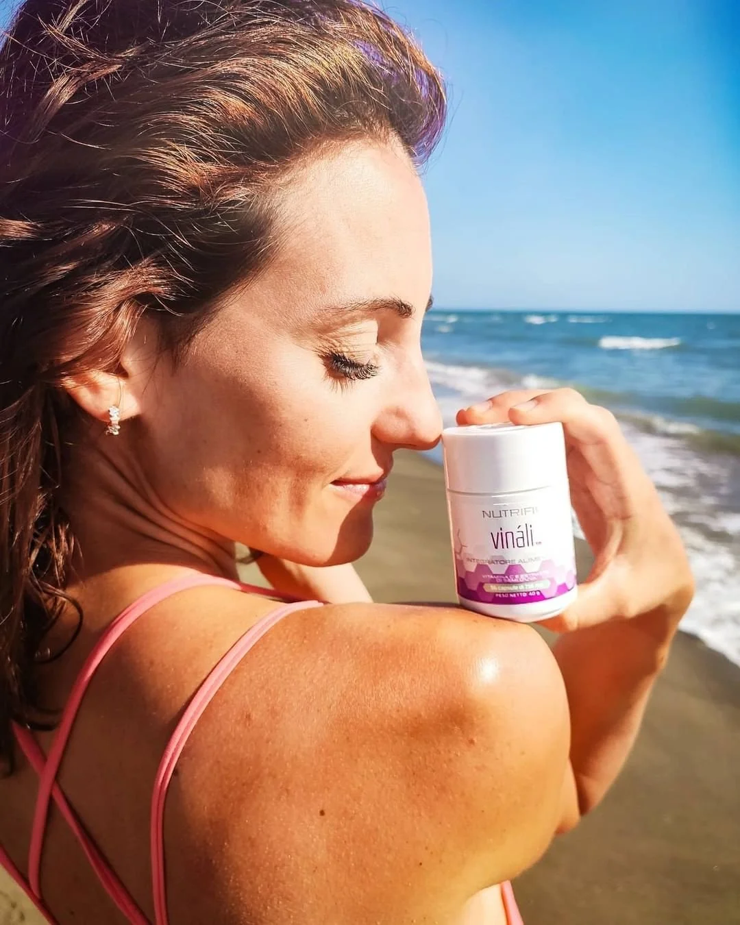 Woman Holding a Bottle of Nutrifii Vinali - Anti-Aging Supplements - on Her Shoulder