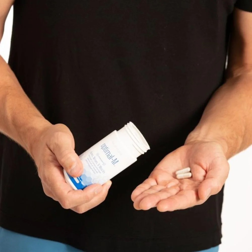 Person Holding 2 Capsules of Nutrifii Optimal-M, High-Quality Multi-Mineral Supplement, on Their Hand
