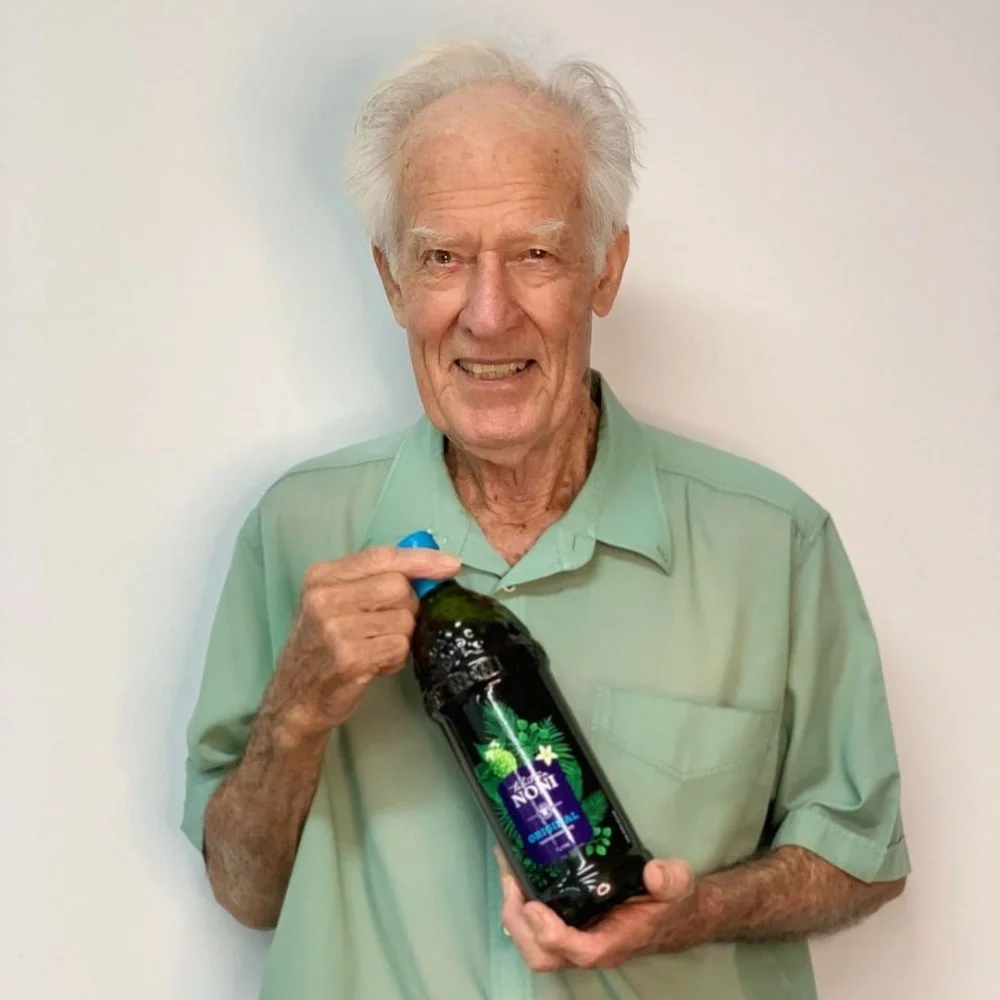 A Man Holding a Bottle of Tahitian Noni Original Juice - Liquid Dietary Supplement