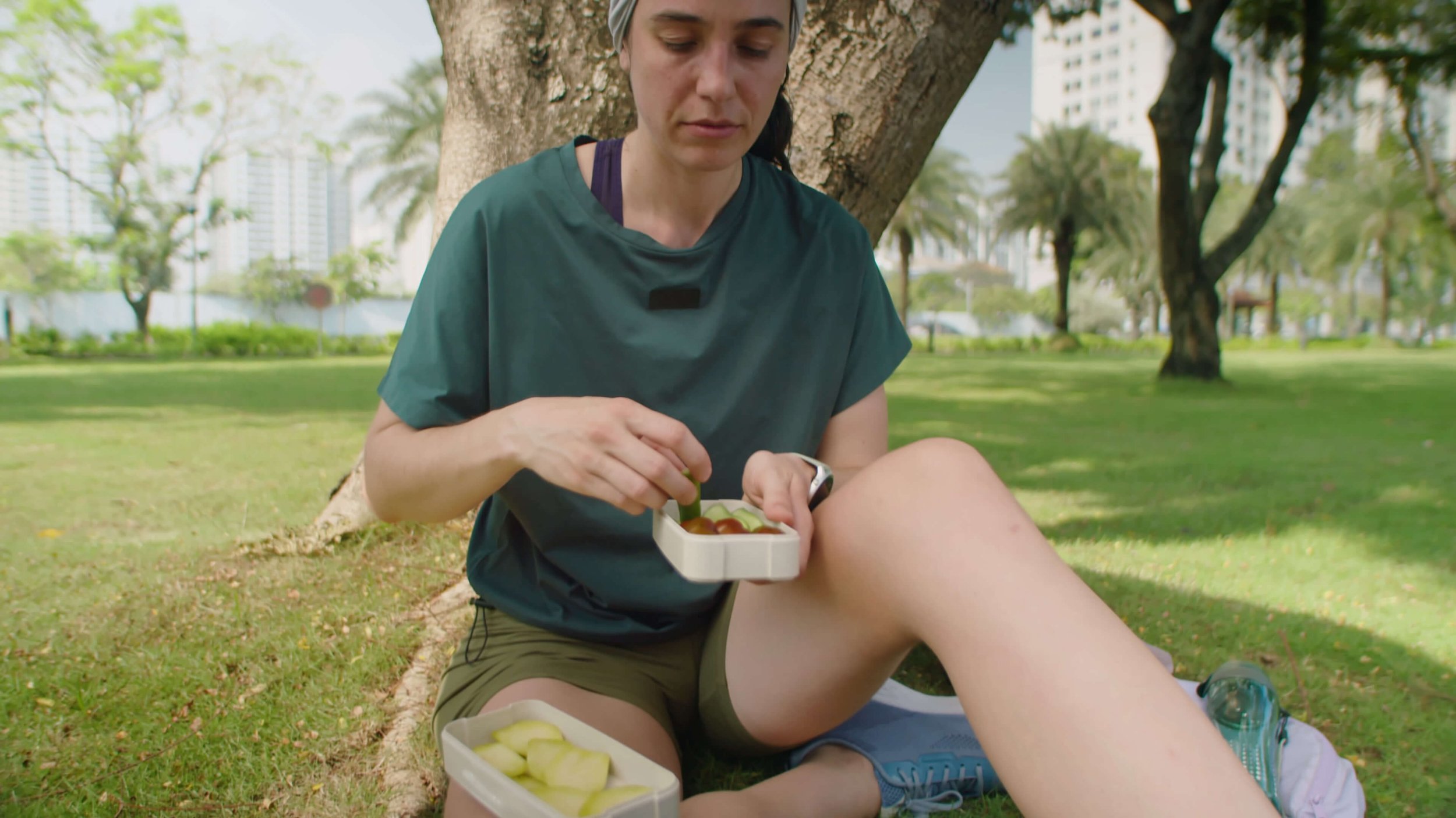 Busy mom sitting outside eating a healthy whole food snack, taking a midday break