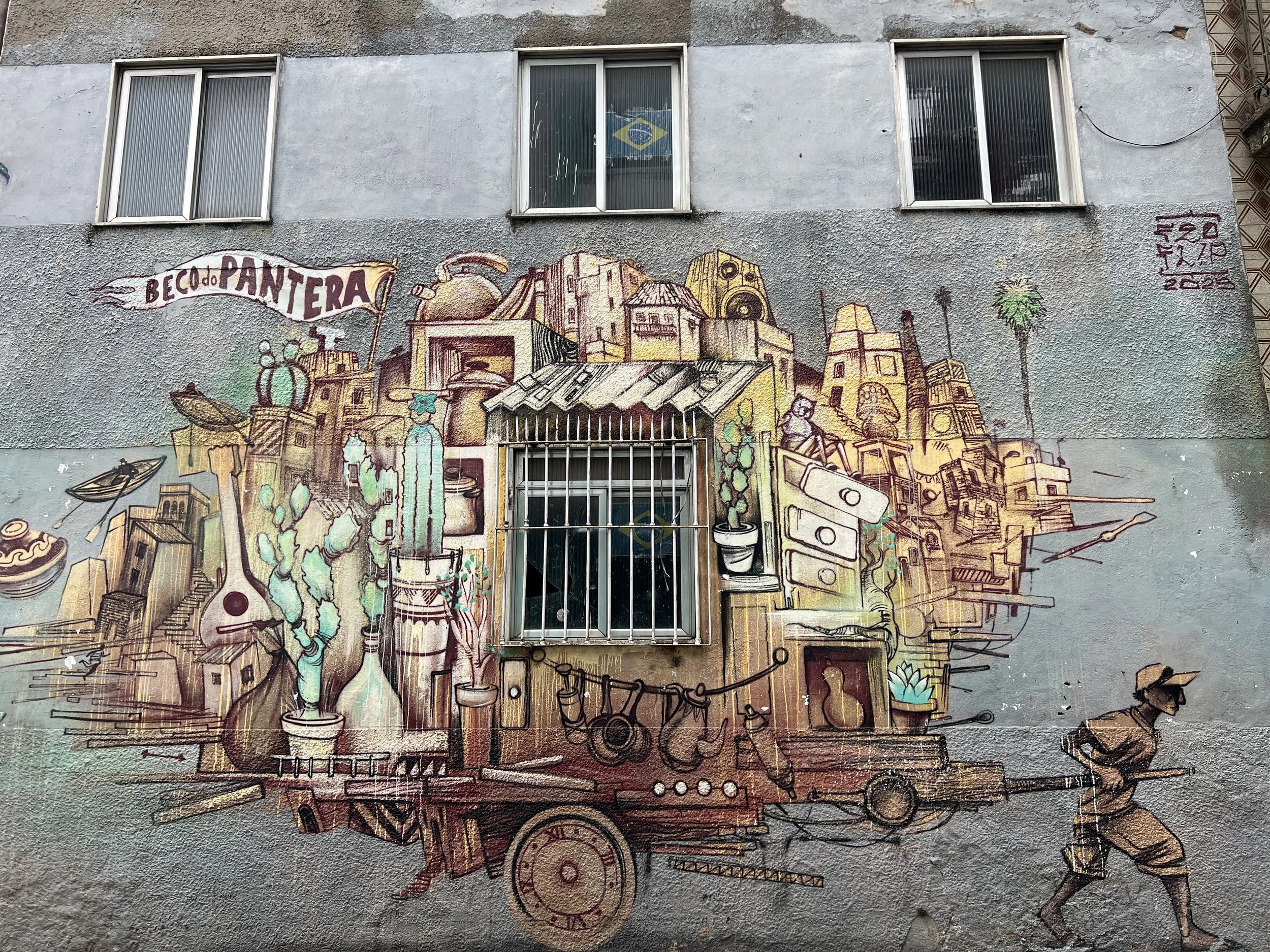 Graffiti mural of a favela house carried on a cart by a man on a wall in Rio de Janeiro, Brazil