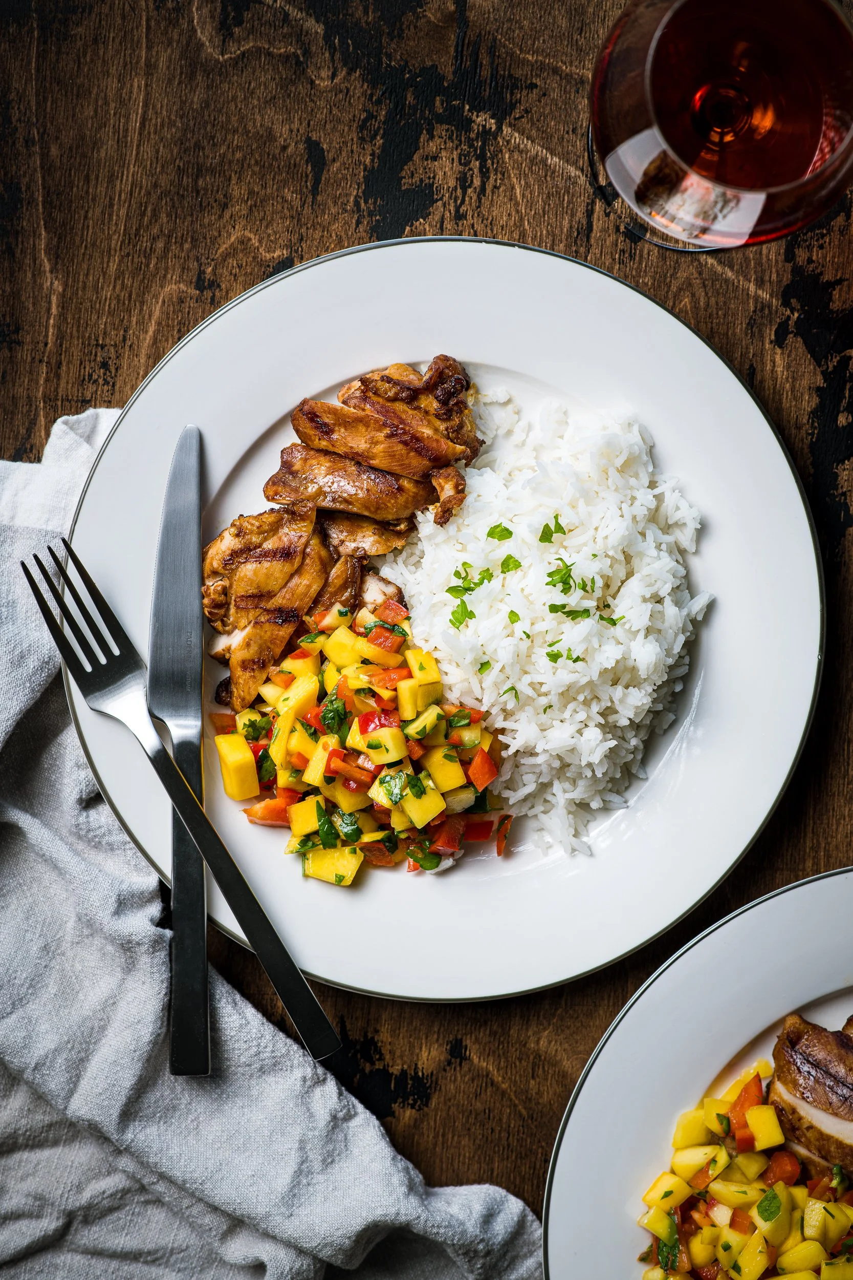 Plate of grilled chicken, rice and mango salsa.