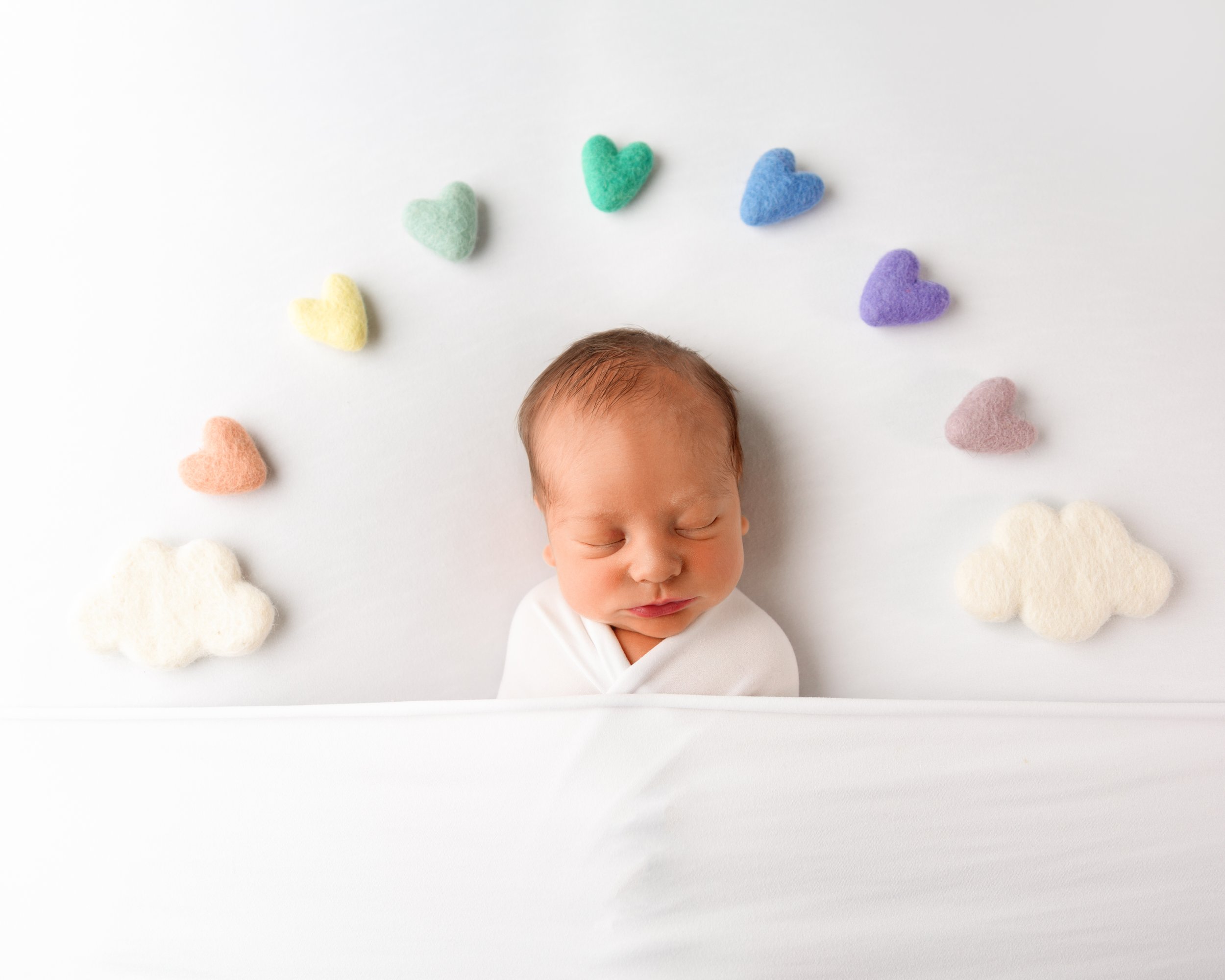 Rainbow of hearts around a newborn baby boy