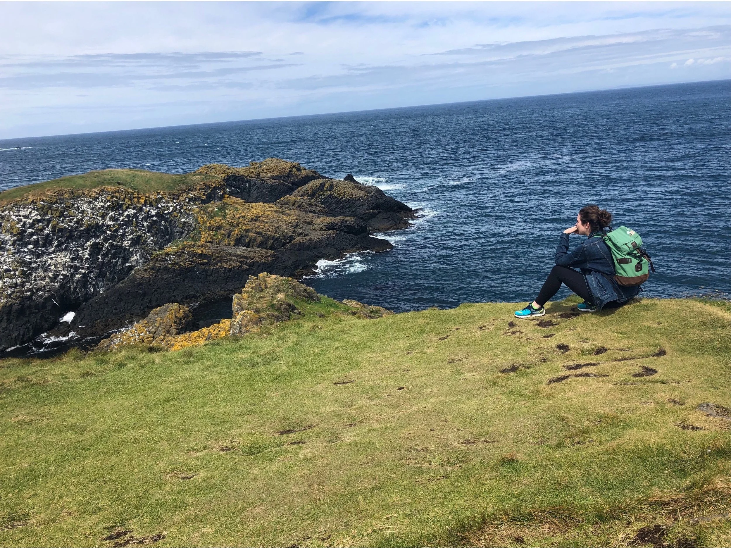 Sitting on a cliff by the sea in Northern Ireland. Photo Credit: Russ, 2018