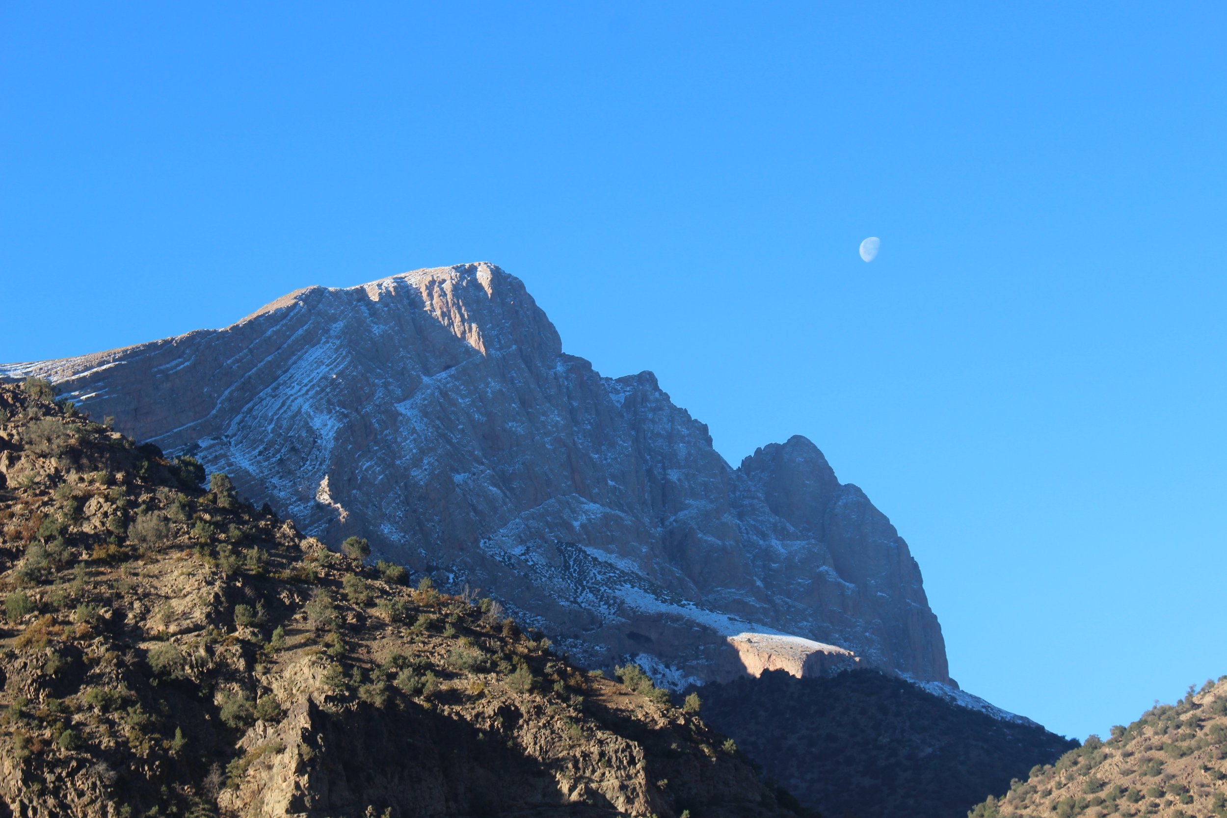   Although it was cold standing outside, in the mornings you can catch a warm view of the mountains with the moon joining in on the photo.  Photo credit: Baldwin, 2023. 