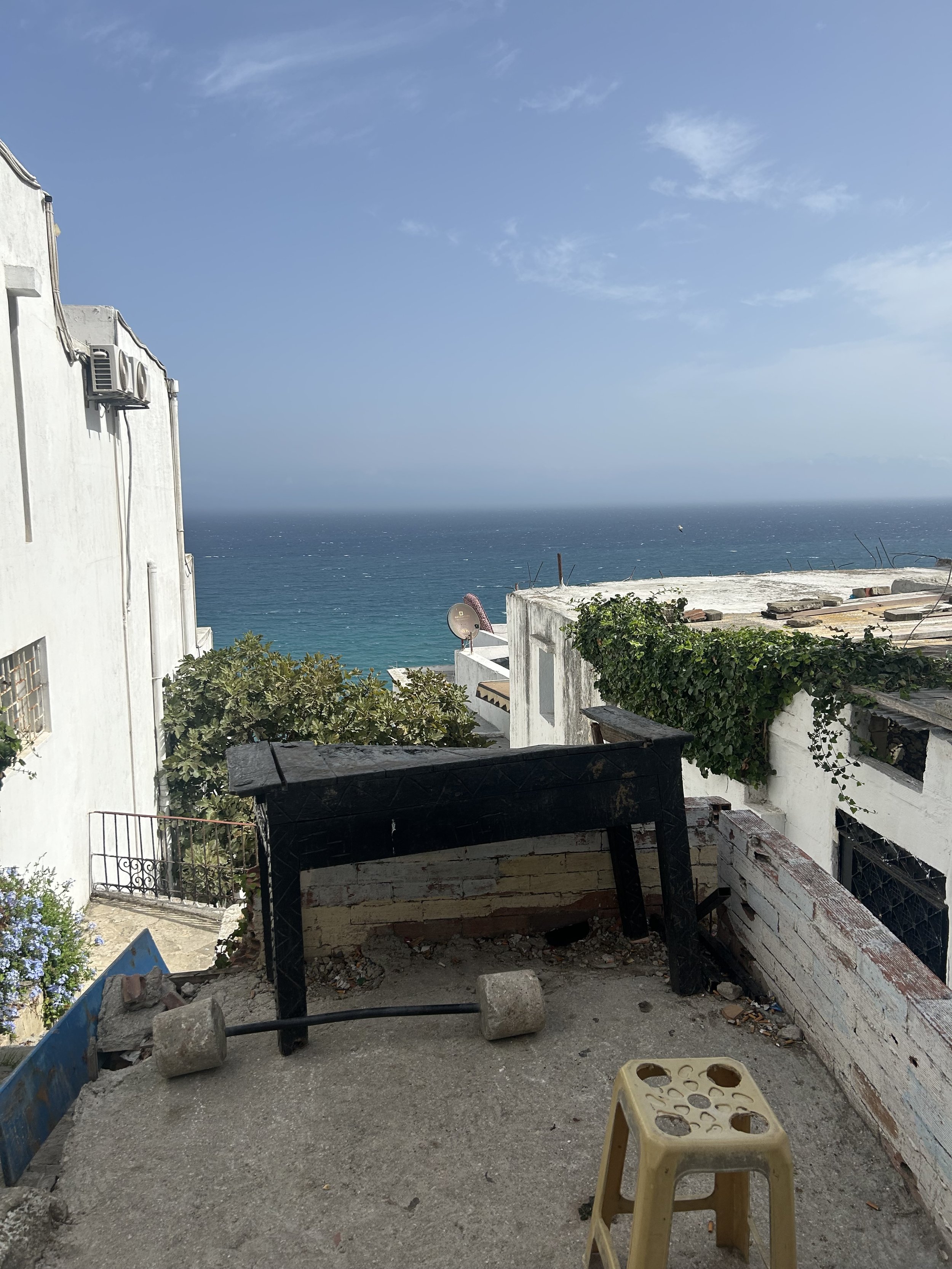 A rudimentary terrace provides a vantage point to see the Mediterranean Sea stretch beyond the white buildings of Morocco