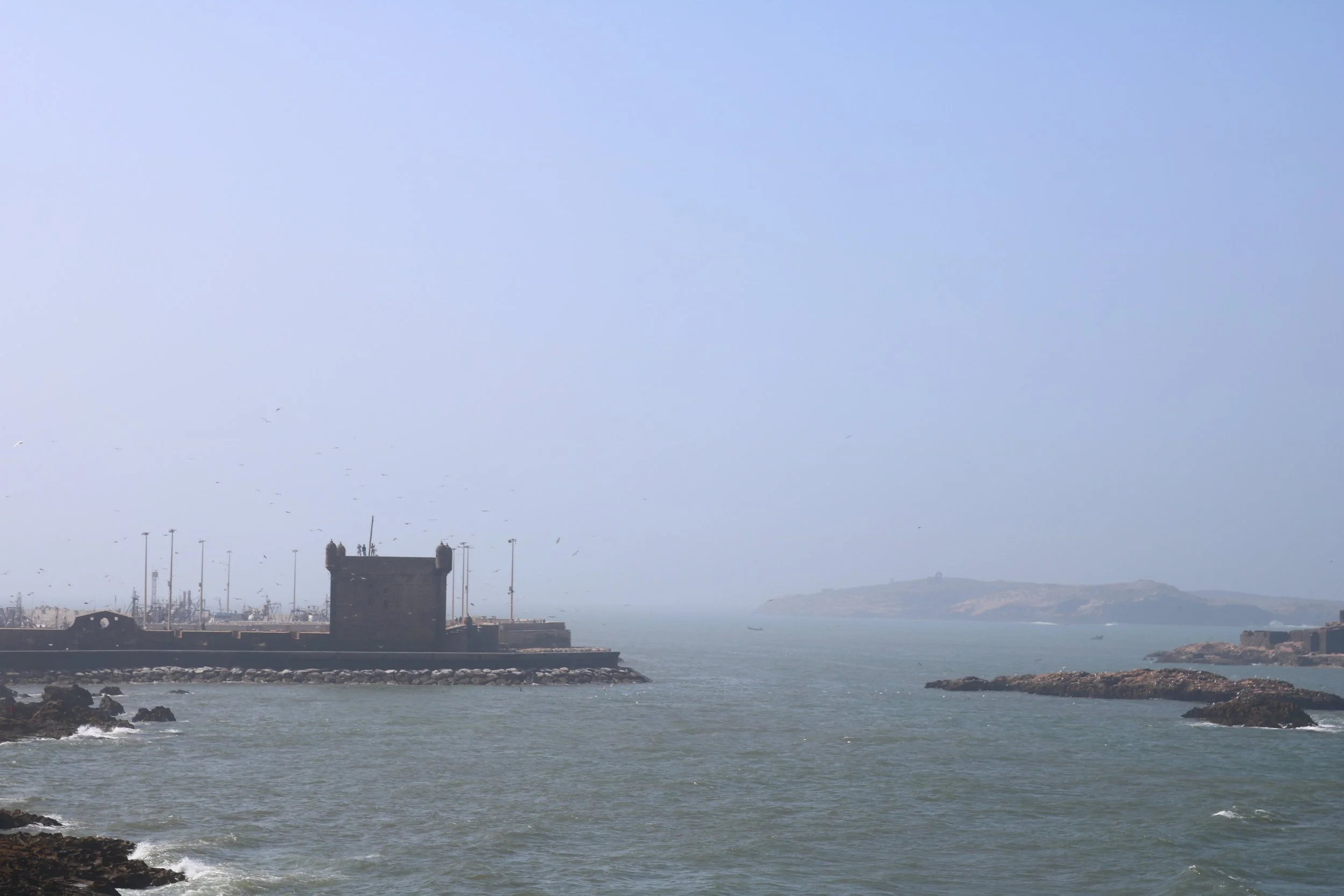 A view across water of an old tower protecting the port.