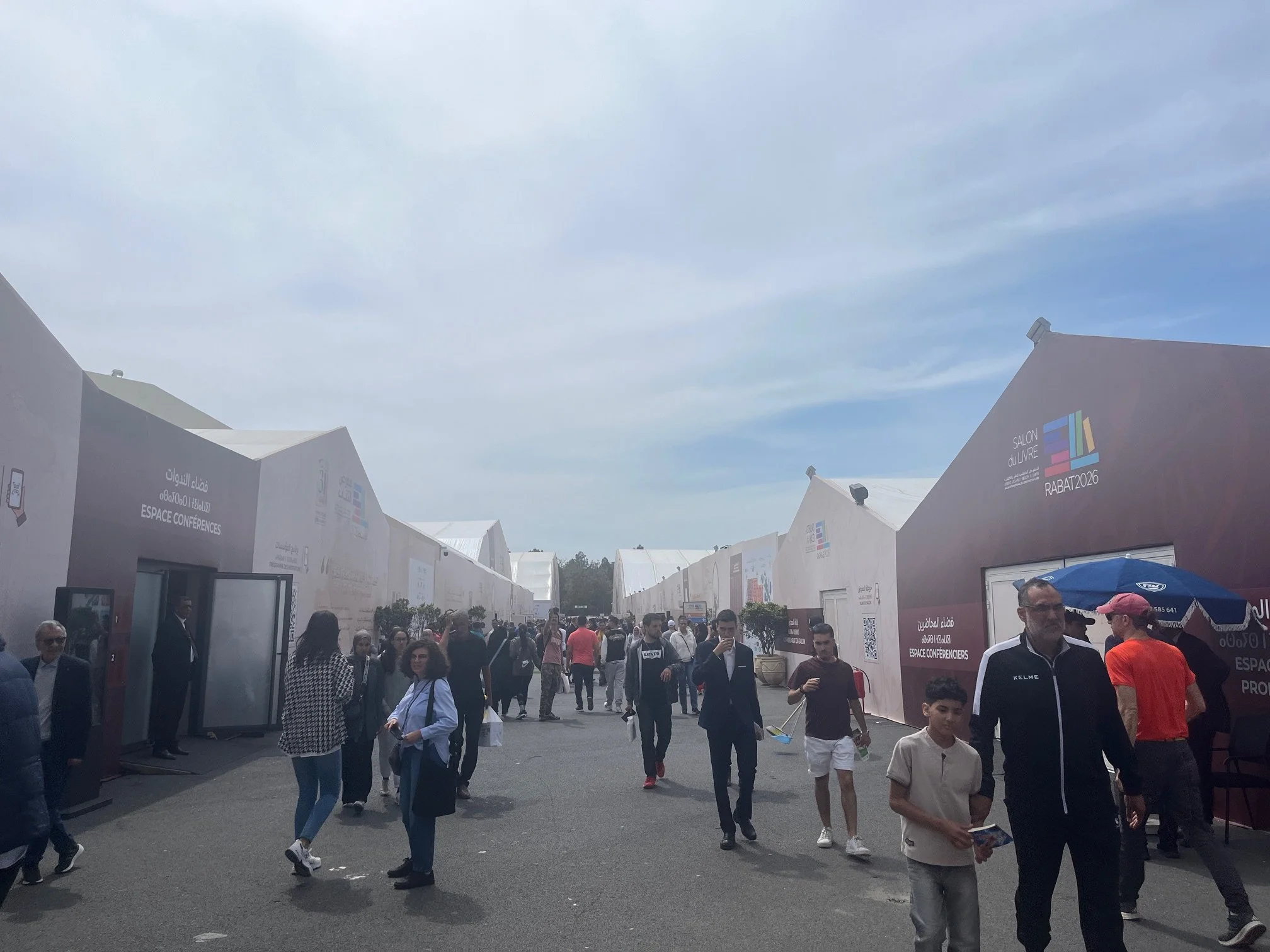 People mill around outside the buildings making up the book fair