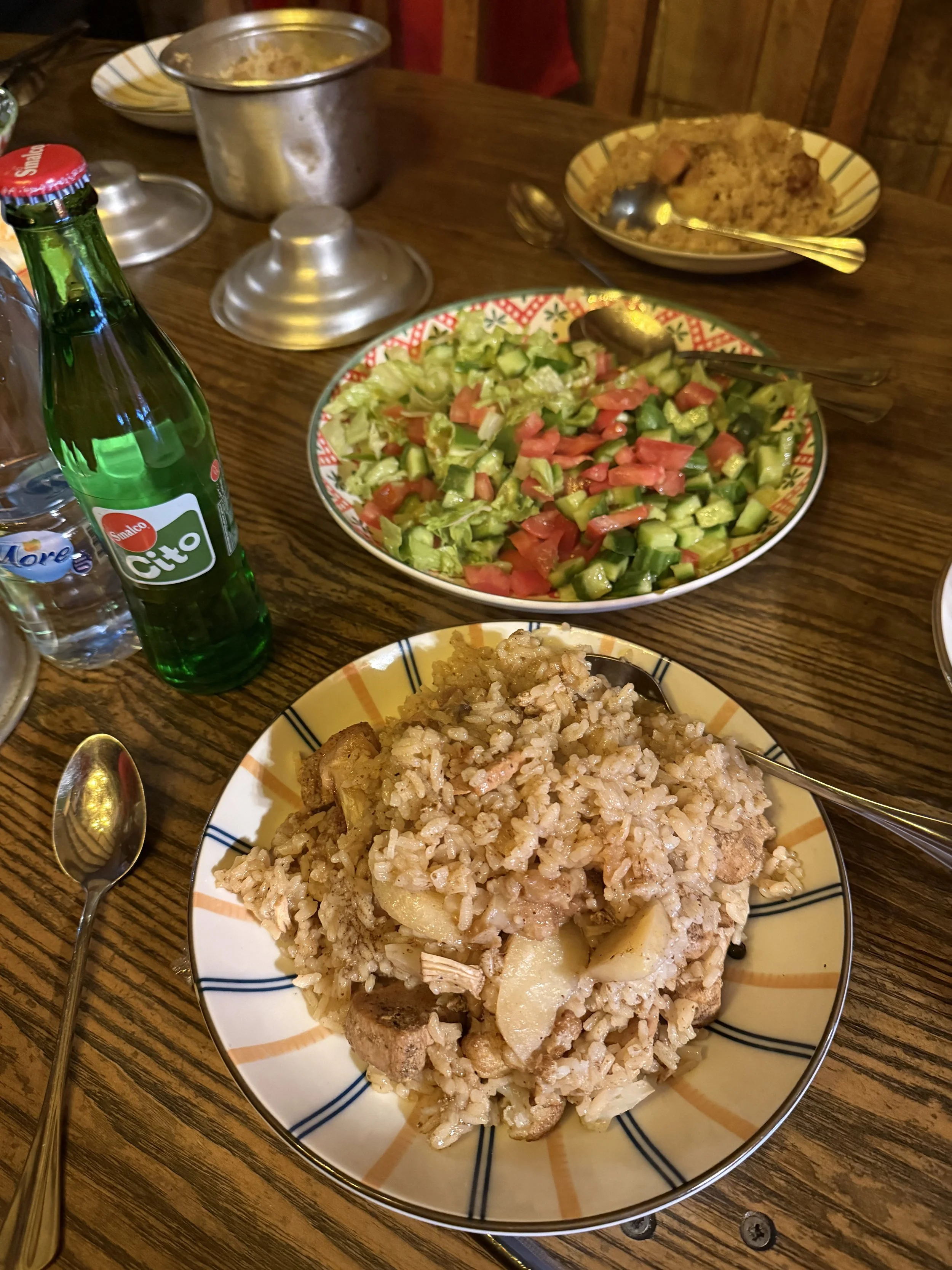 A plate of rice and meat, and a green salad.
