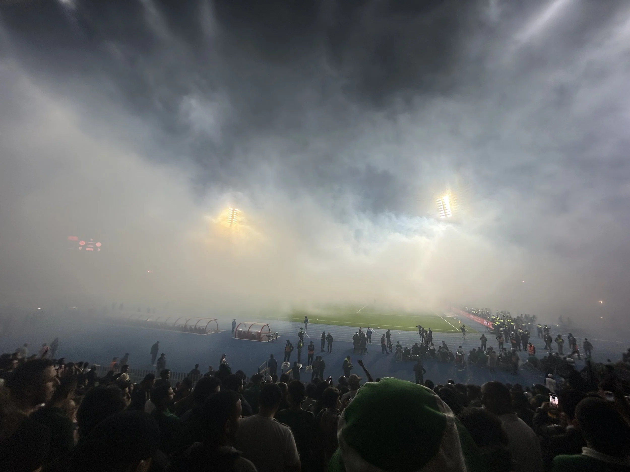 The football pitch is covered in smoke from flares fans set