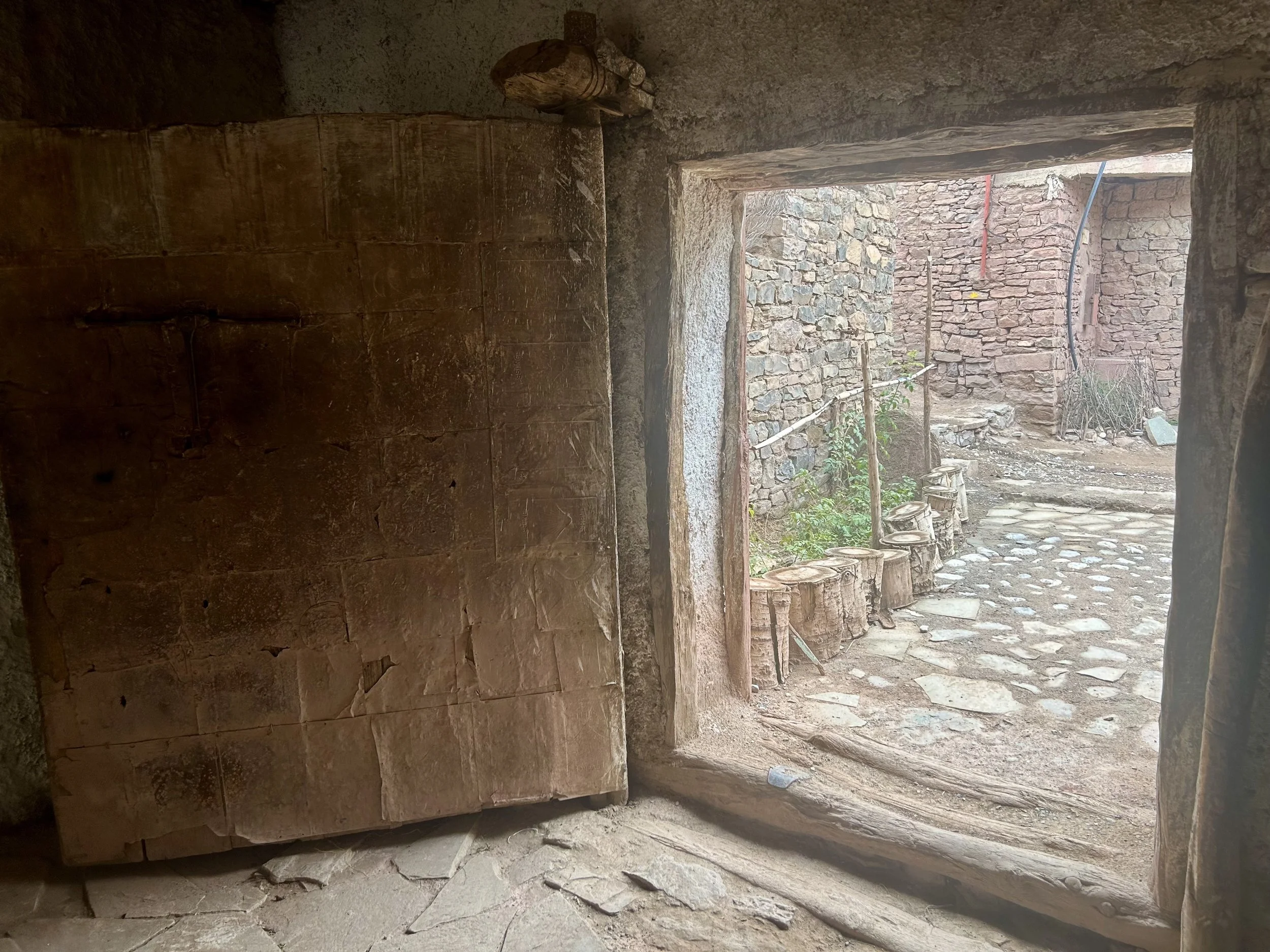 Inside a home looking out a rudimentary square door frame.