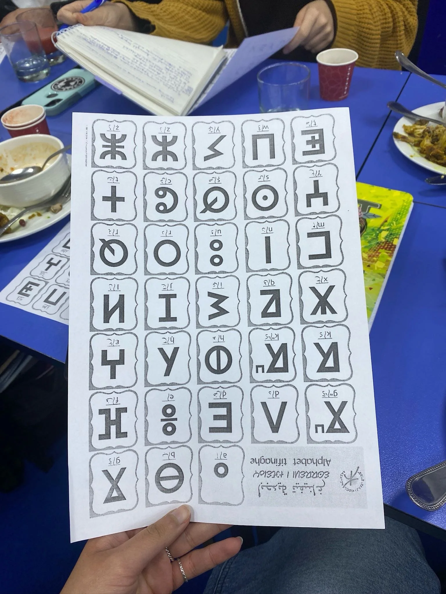 Nadia holds a paper with the tifinagh alphabet